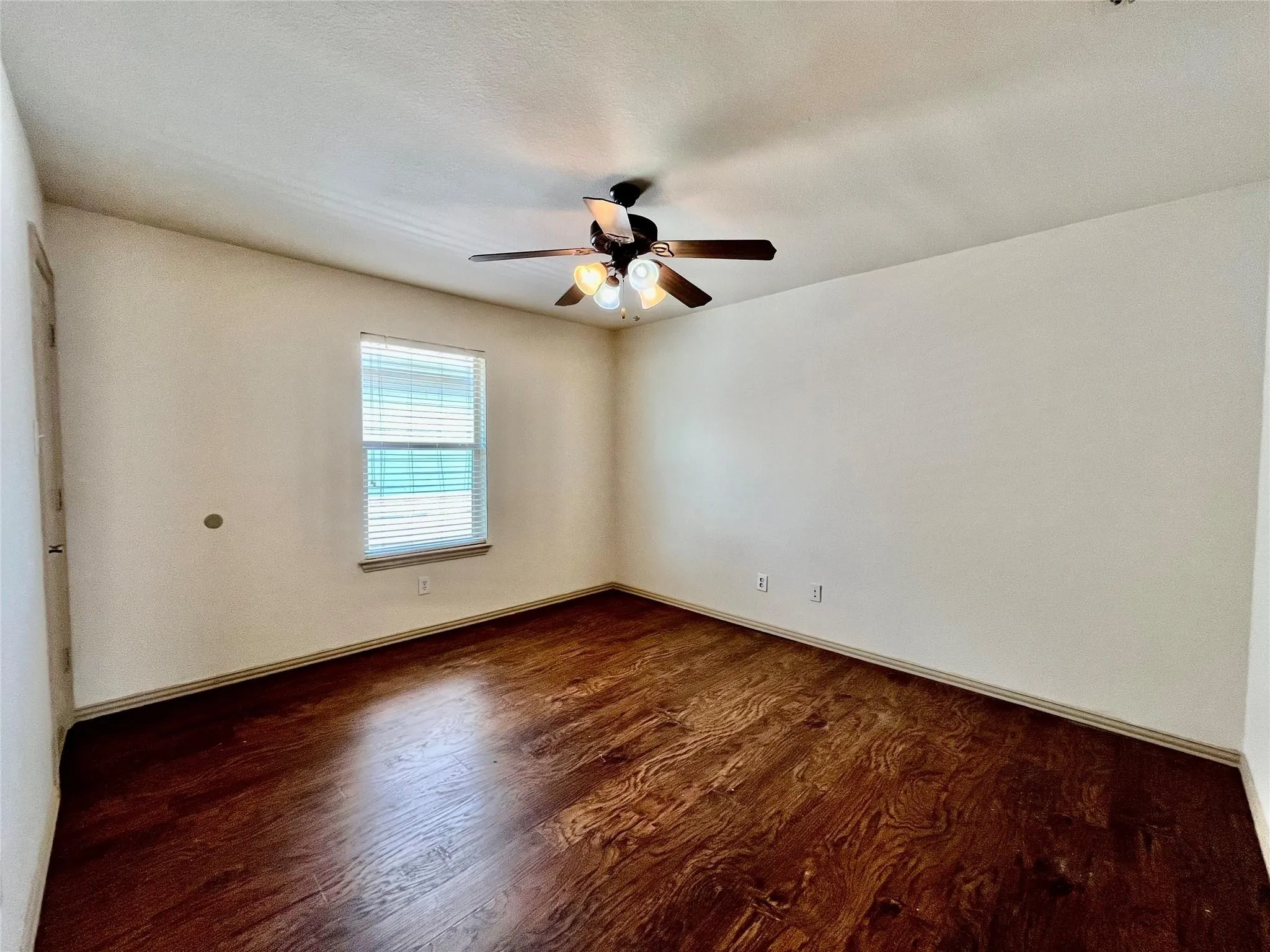 Bedroom with wood flooring, ceiling fan, window, and closet