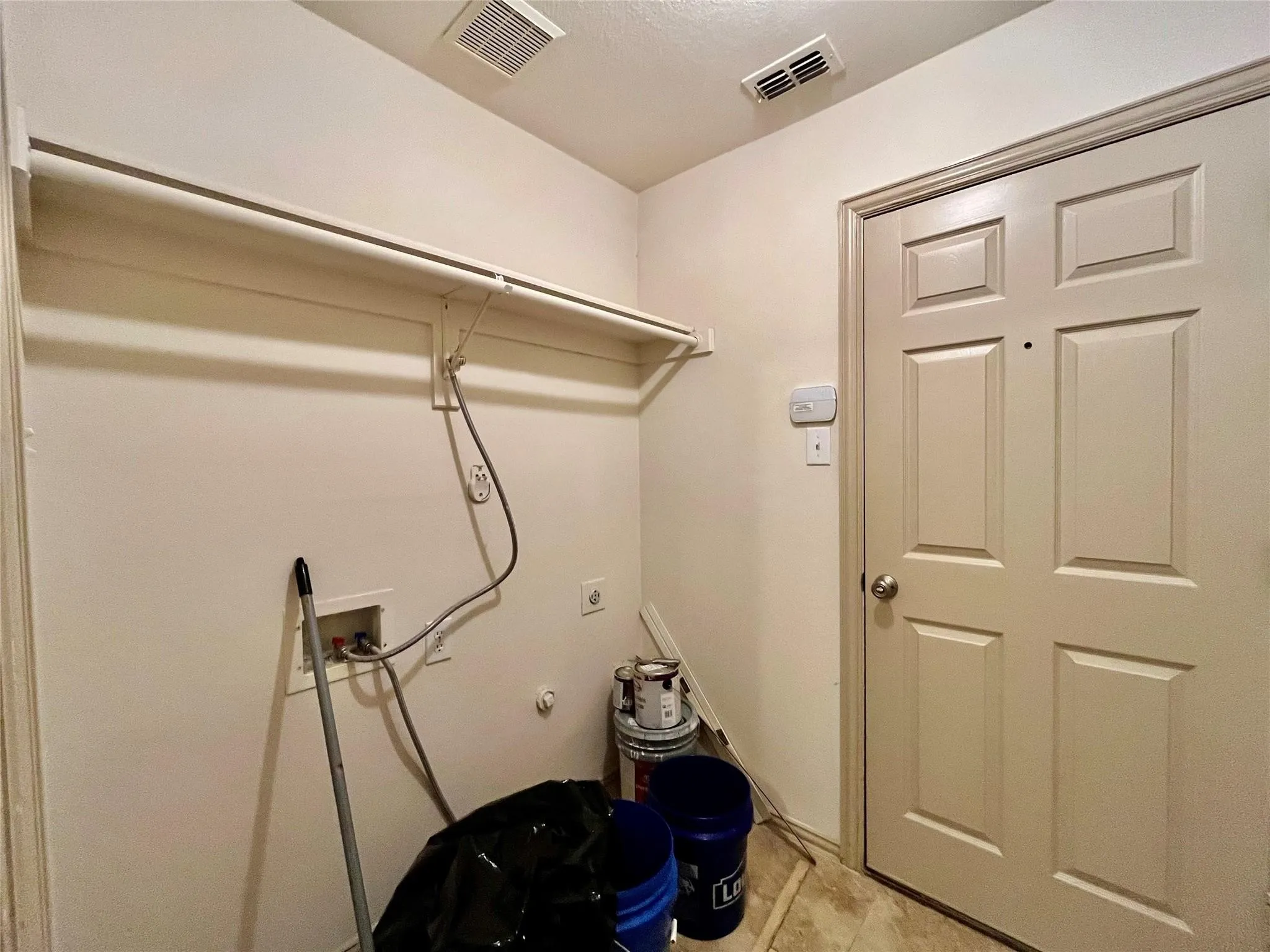 Laundry area with hookups, shelving, and utility sink.