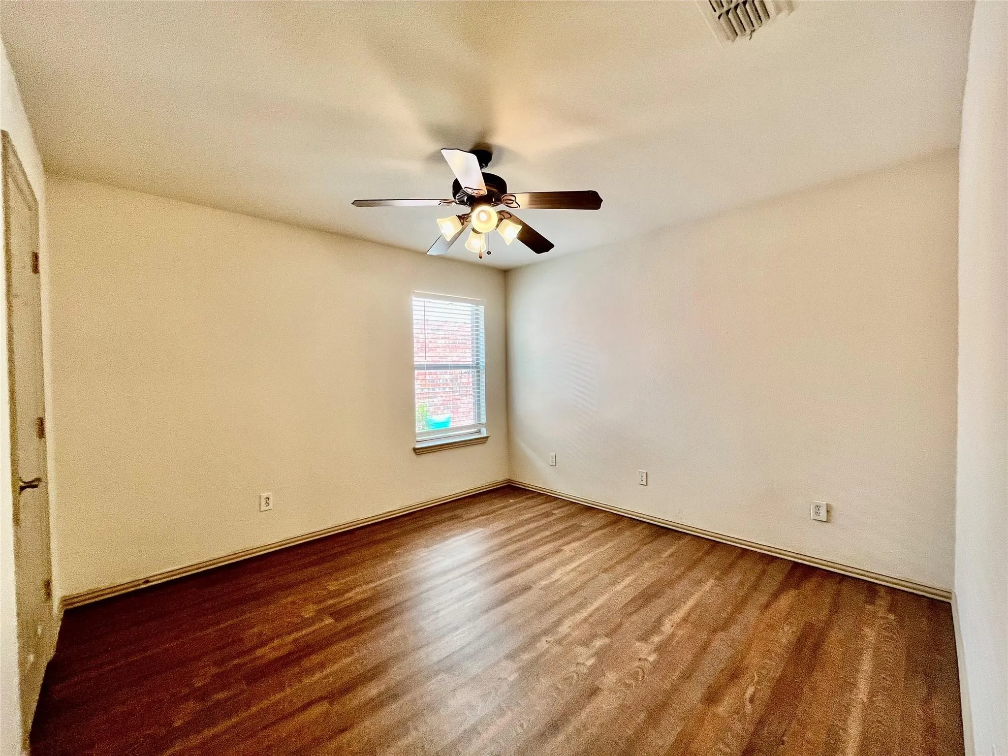 Bedroom with wood flooring, ceiling fan, window, and closet