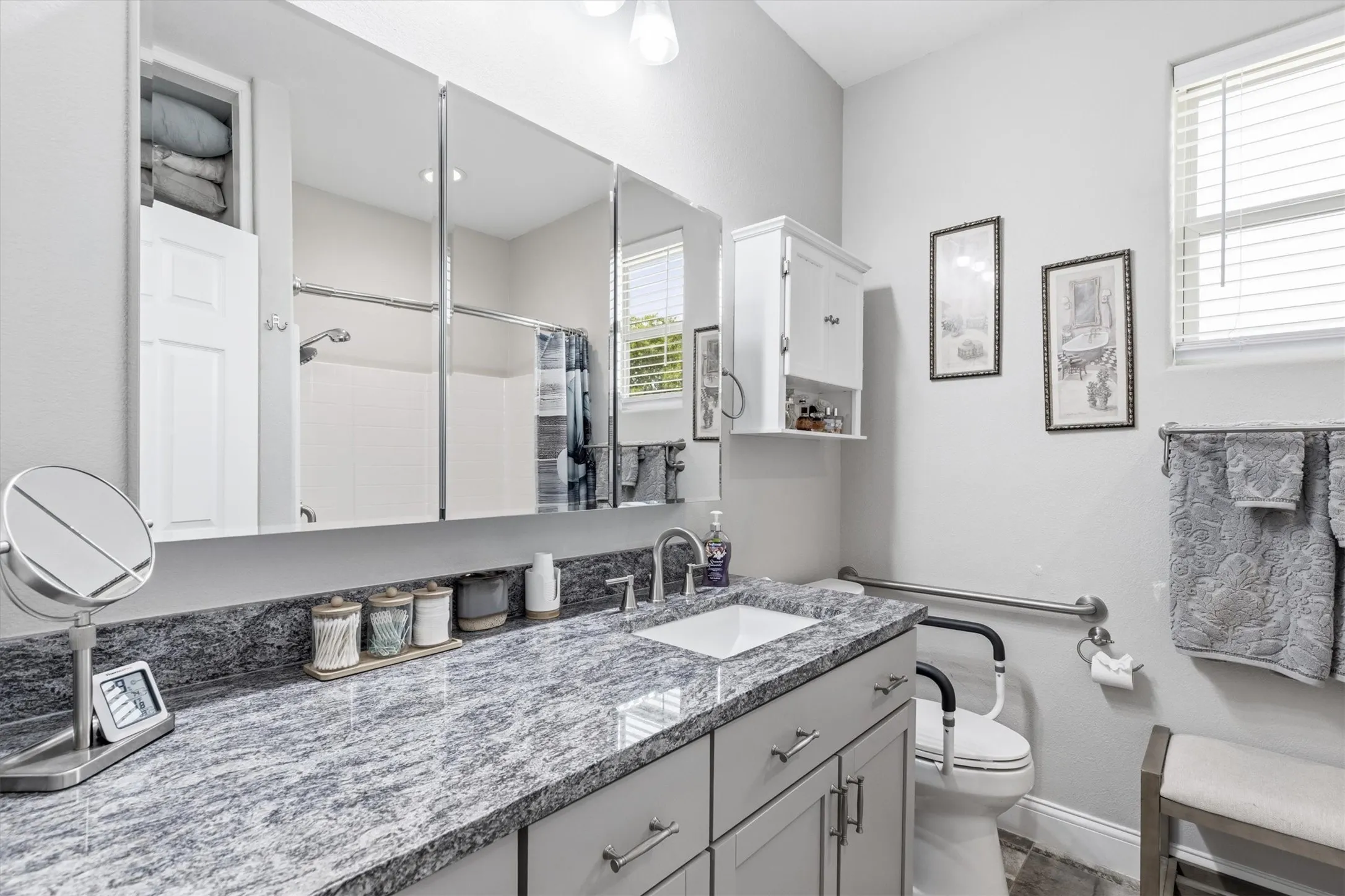 The bathroom in the guest house has granite countertops, ample storage with a built in mirror cabinets and a linen closet next to the shower/tub combo.