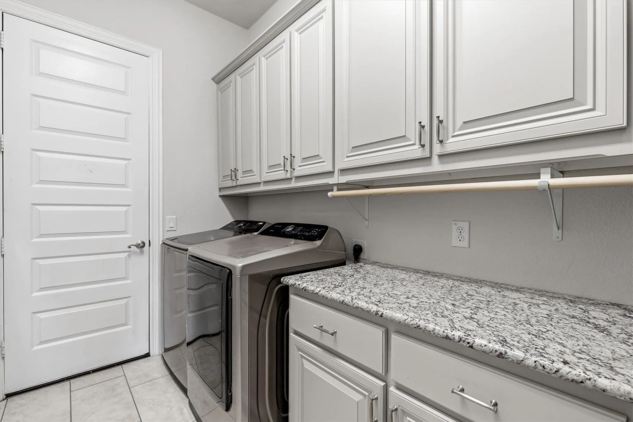 Plenty of cabinet storage, granite counter space and a hanging rod for air-drying items and still room for a second refrigerator. The door leads straight out to the garage.