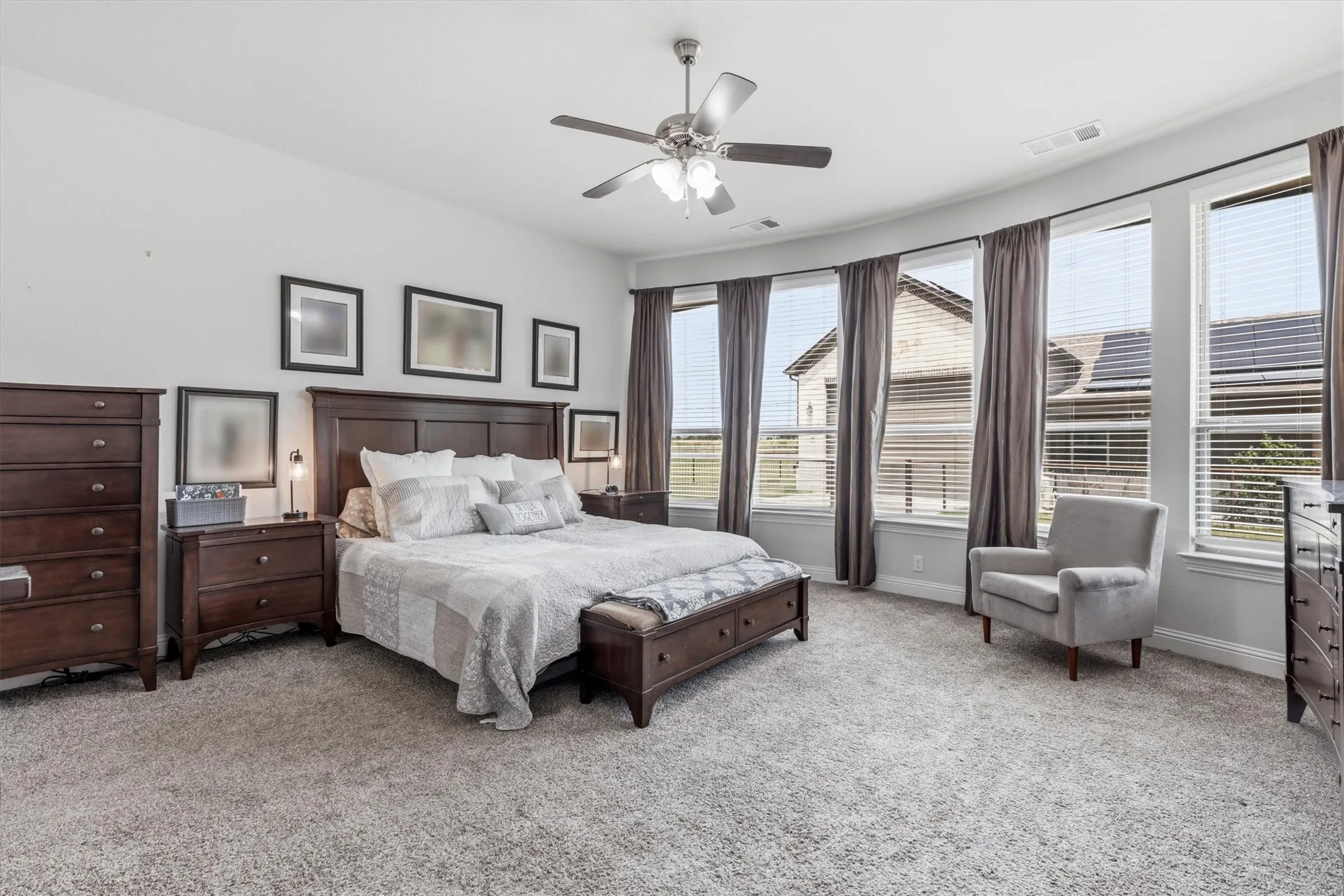 Generously sized primary suite with a wall of windows and still has plenty of wall space for dressers and additional furniture.