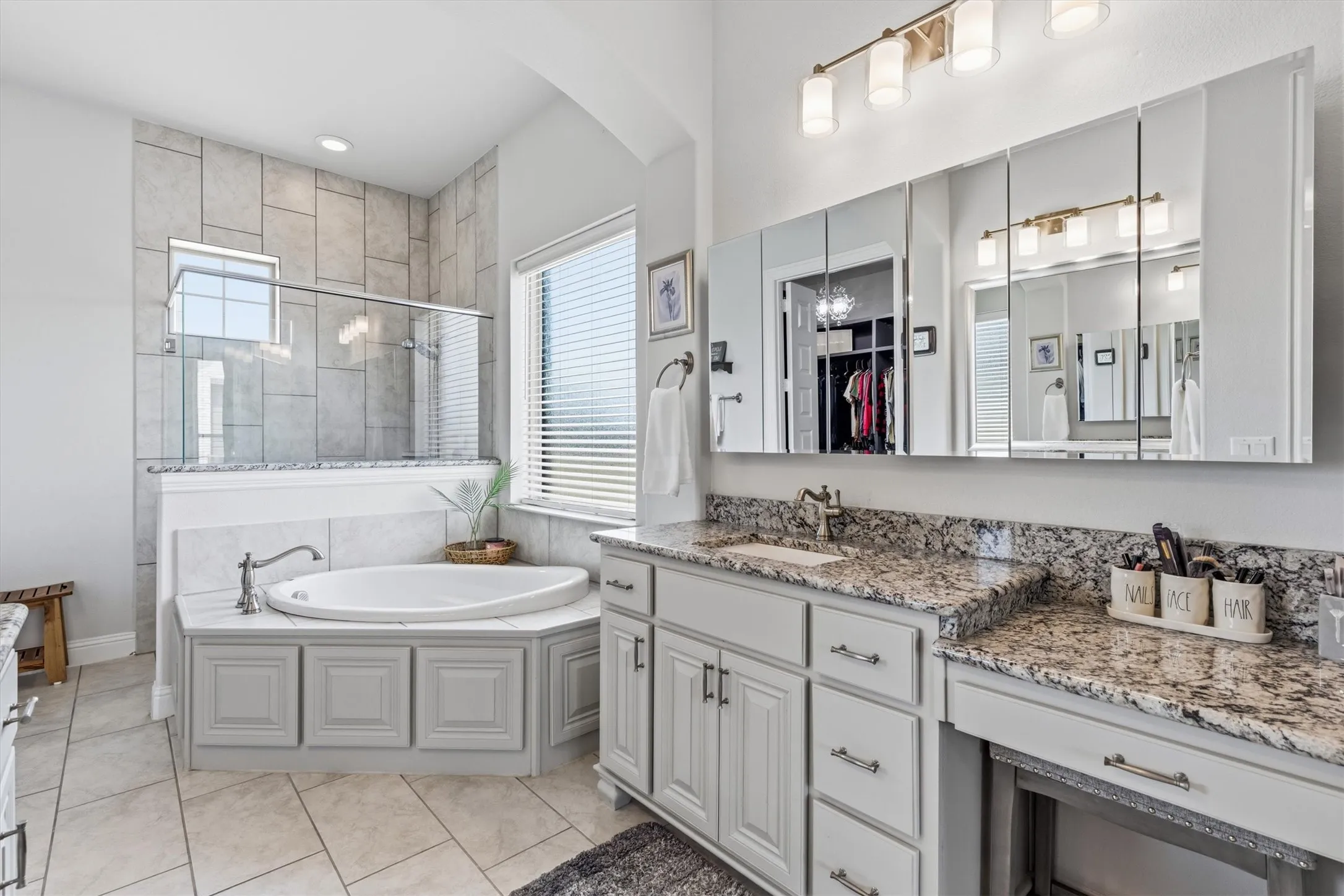 Separate granite vanities, a corner soaking tub, walk-in glass shower.