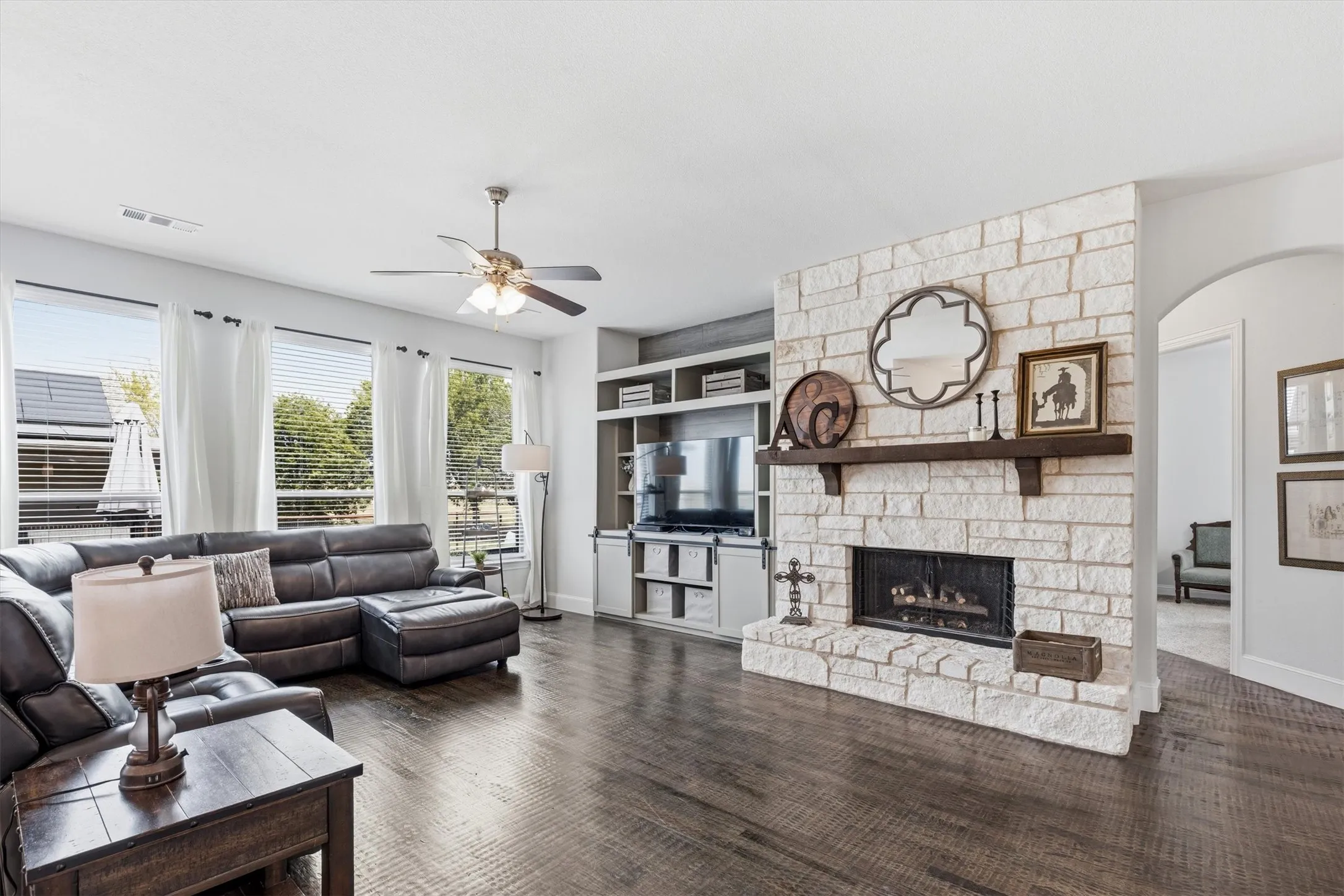 A stunning stacked-stone fireplace, hardwood floors and abundance of natural light from oversized windows.