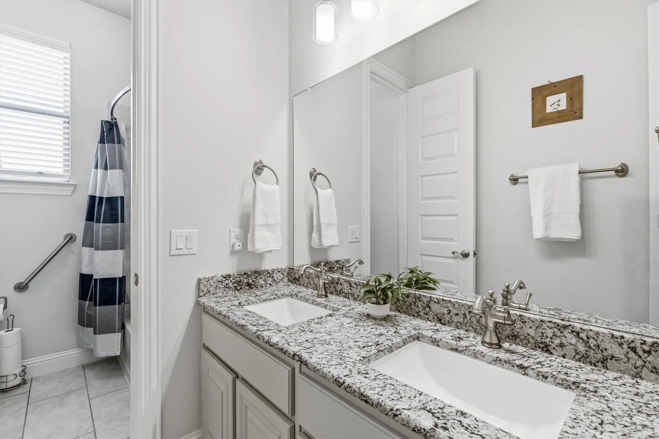This guest bathroom features a double sink granite vanity, set apart from the shower/tub combo so more than one person can get ready at once.