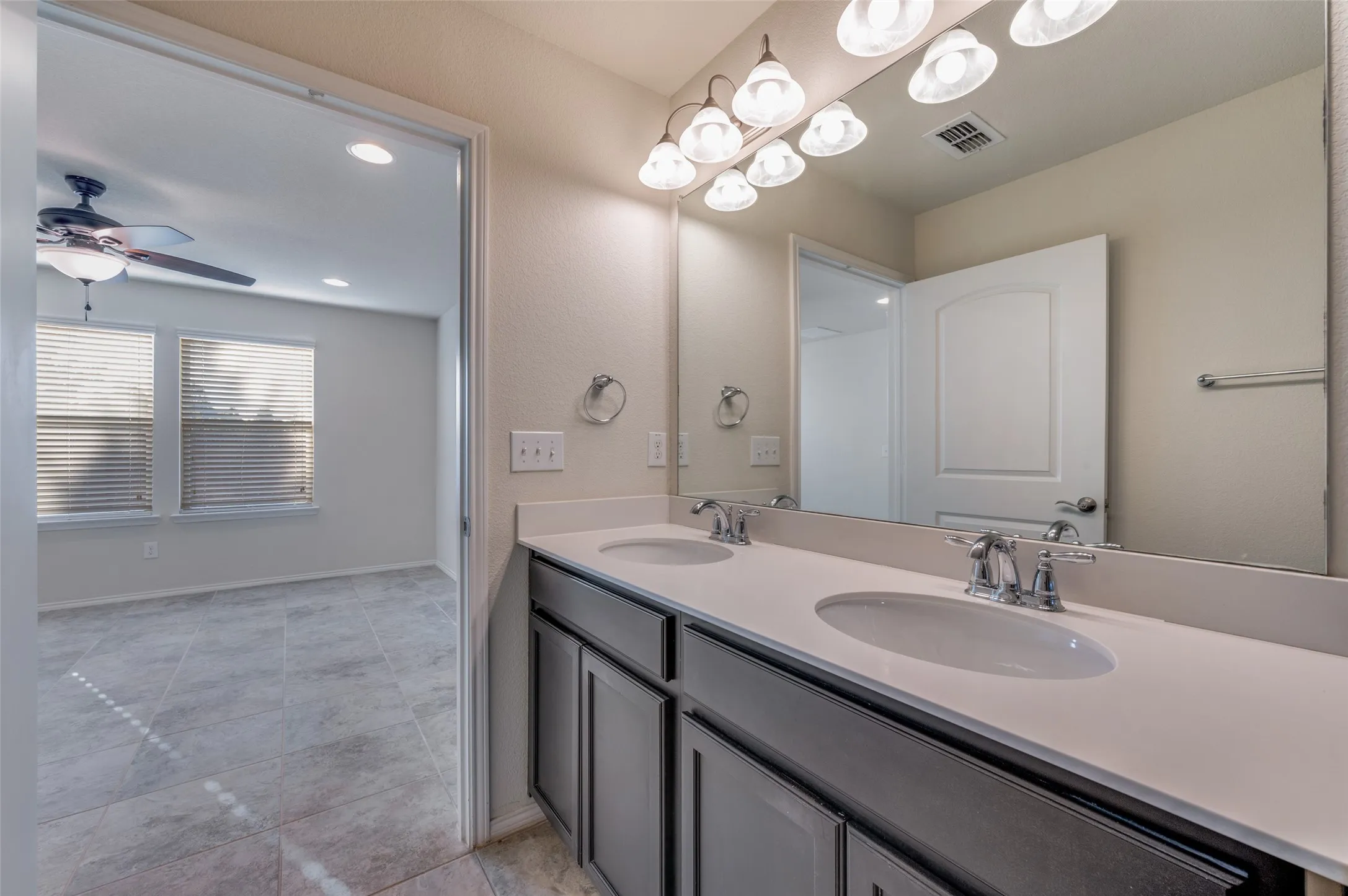Dual vanity with undermount sinks, chrome fixtures, and a large mirror