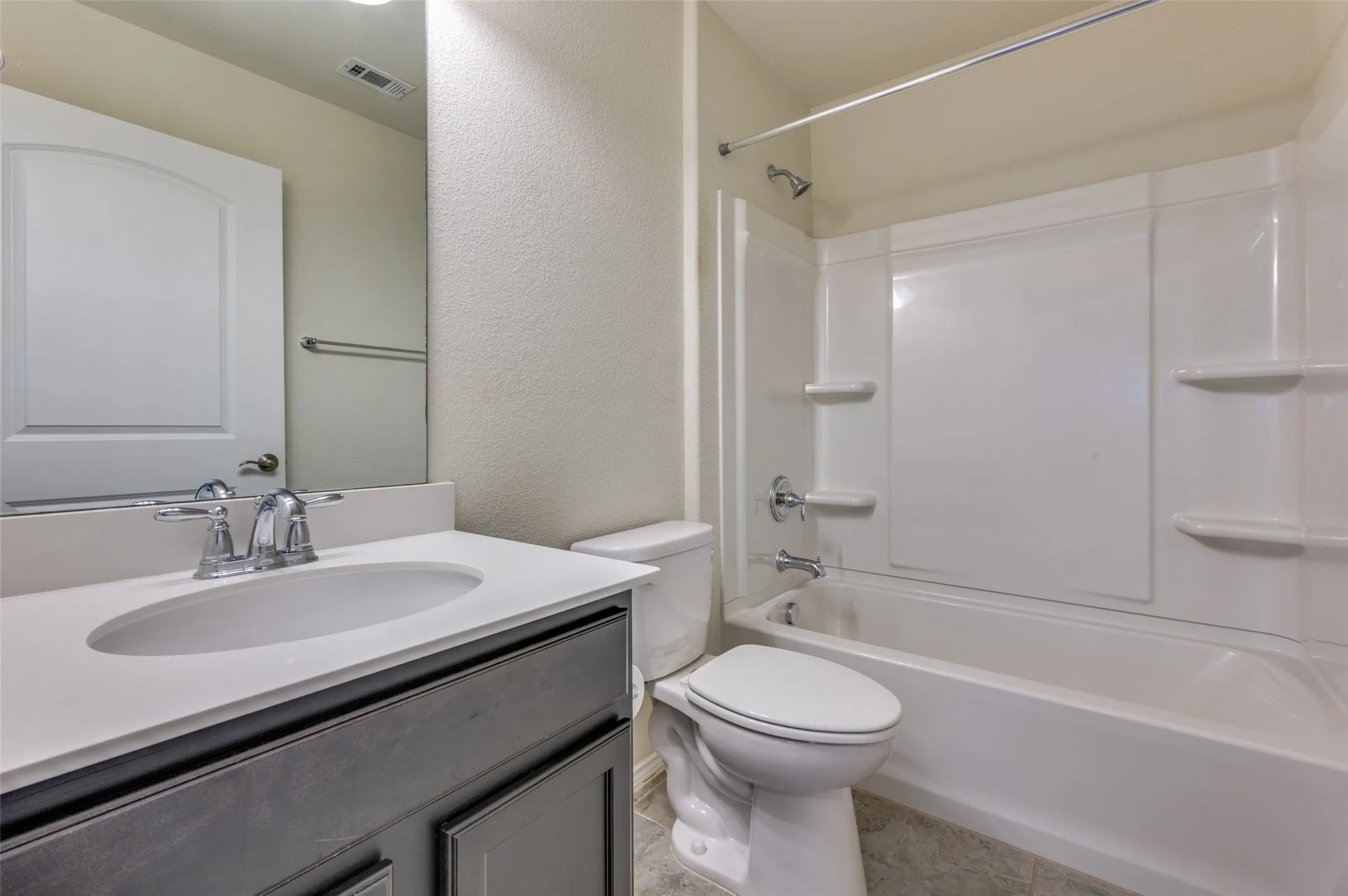 Bathroom featuring a single vanity with an integrated sink, polished chrome faucet, and a large mirror