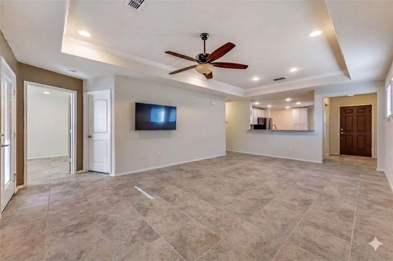 Recessed lighting, ceiling fan, tray ceiling, tile flooring, and a breakfast bar
