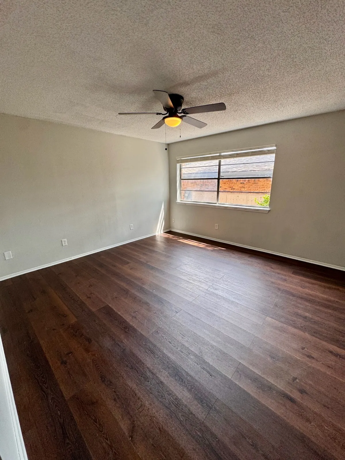 Wood-finish flooring throughout, paired with a ceiling fan light fixture
