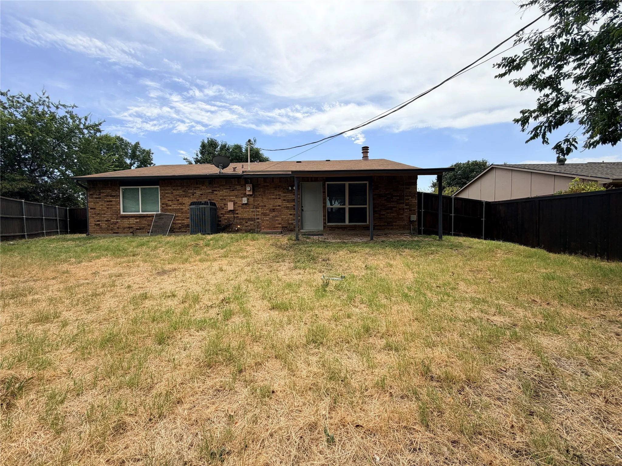 Brick exterior with a covered patio and fenced yard