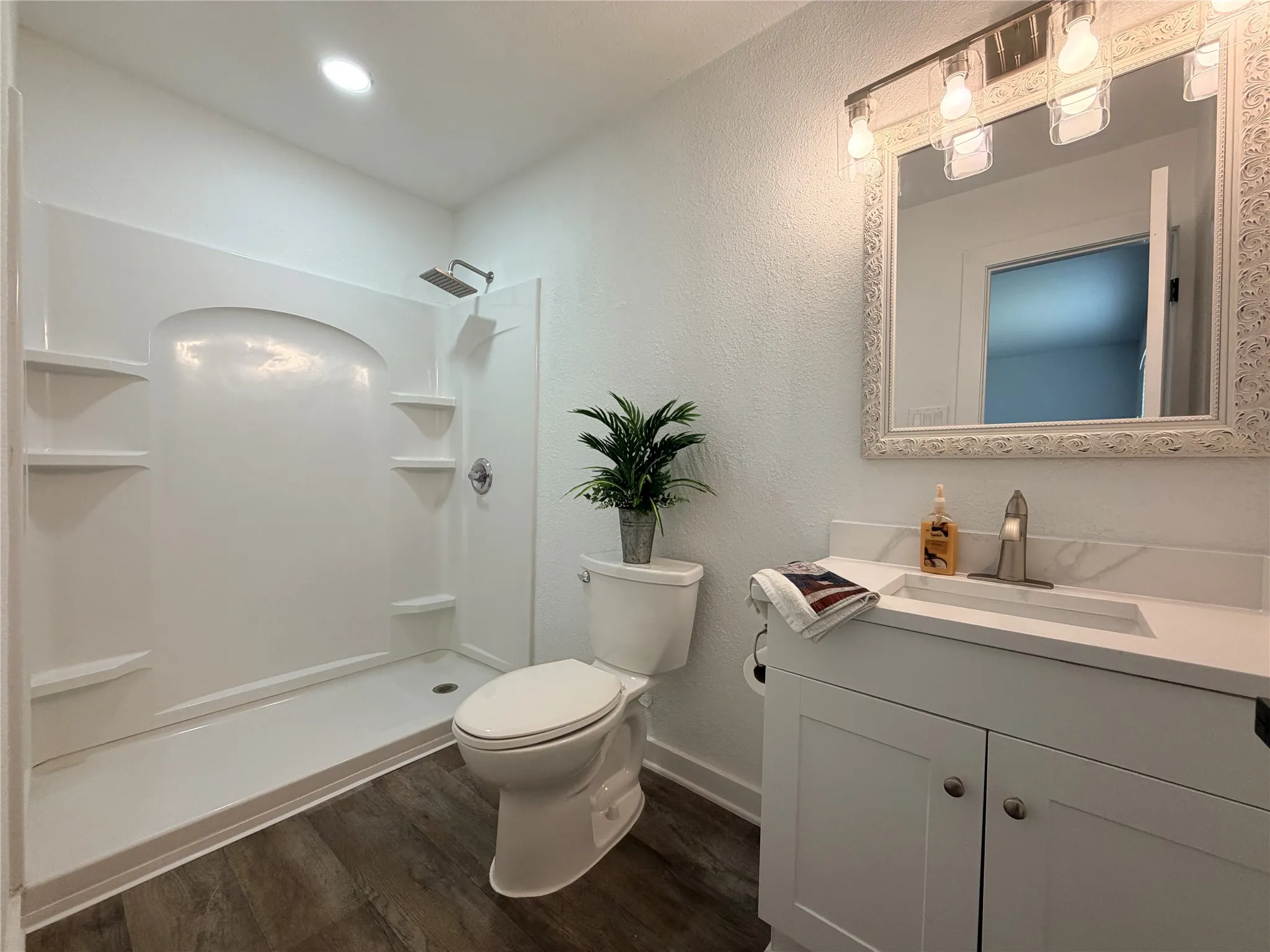 Modern bathroom with a white vanity featuring a quartz-finish countertop and undermount sink