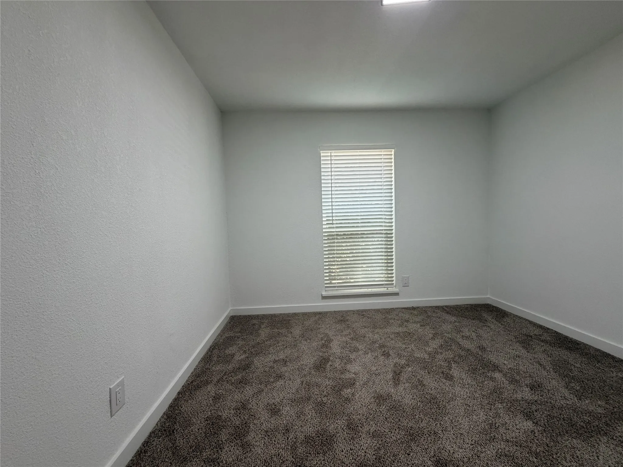 Window with horizontal blinds, textured walls, wall-to-wall carpeting, and recessed ceiling lighting