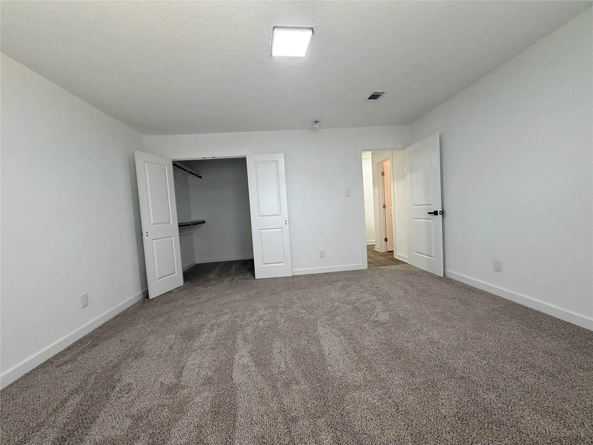 Plush carpet flooring, white interior walls, white paneled doors, closet with built-in shelving, and recessed lighting