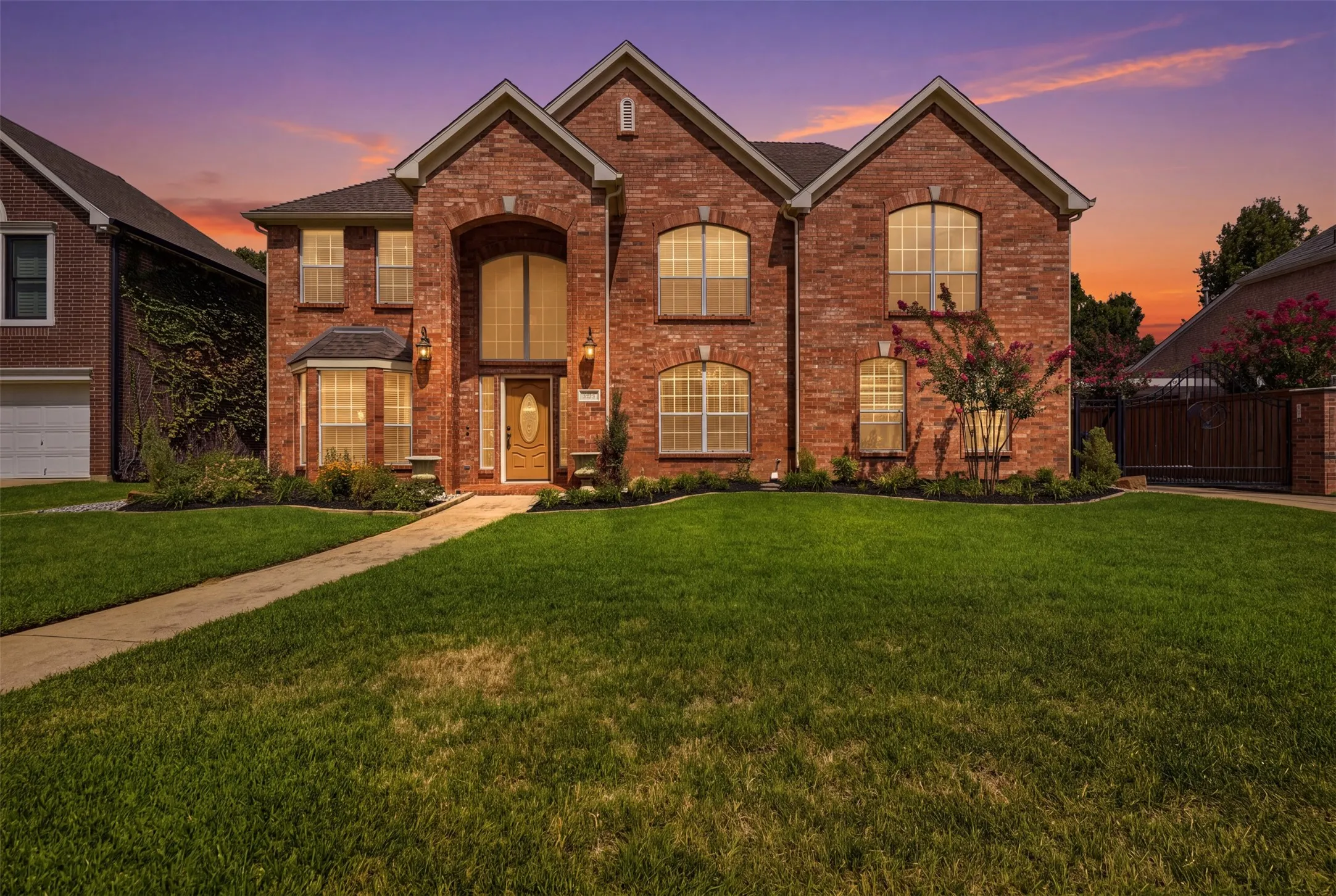 Two-story brick exterior featuring multiple gables and an arched entry