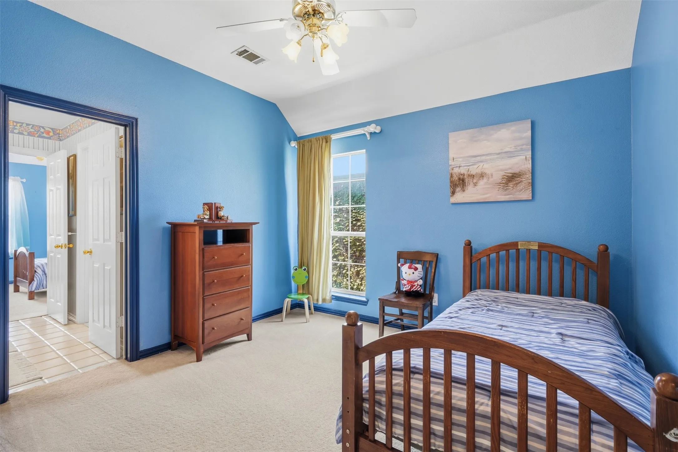 Room featuring a vaulted ceiling with a ceiling fan, a large window with vertical blinds, and neutral carpet flooring