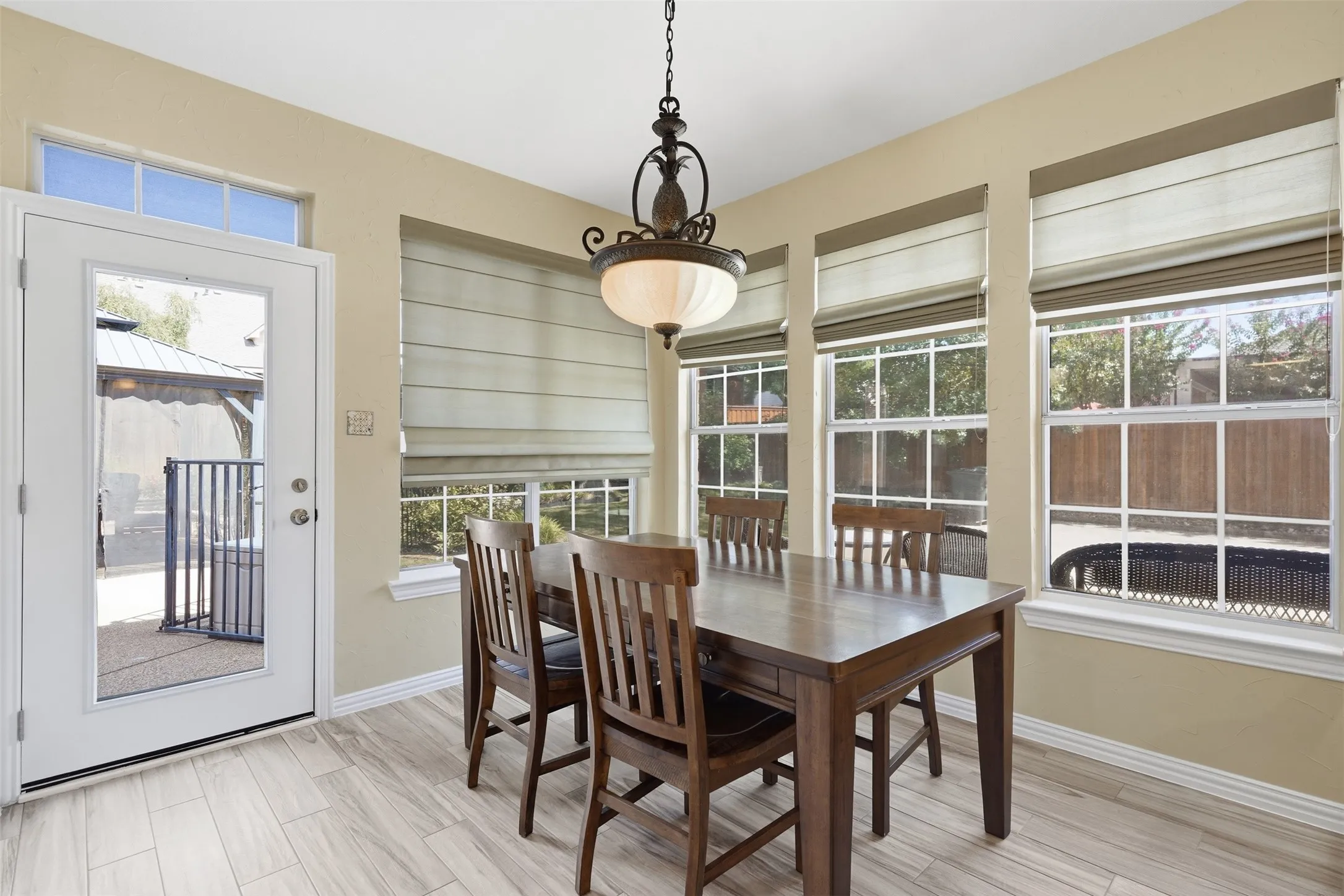 Bright dining area featuring wood-finish flooring and a glass-paneled door