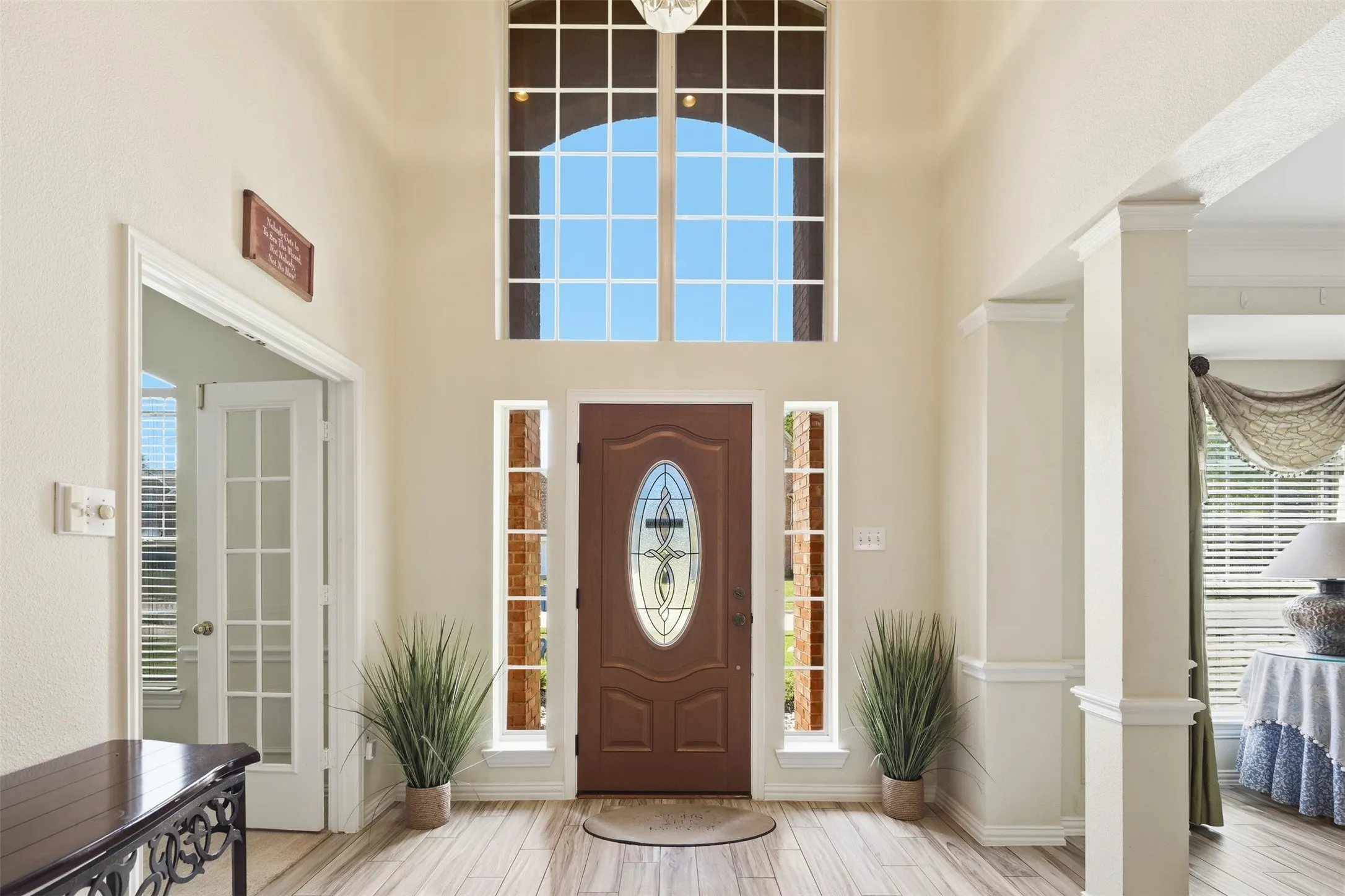 Welcoming foyer showcasing soaring ceilings with transom window flooding the space with natural light