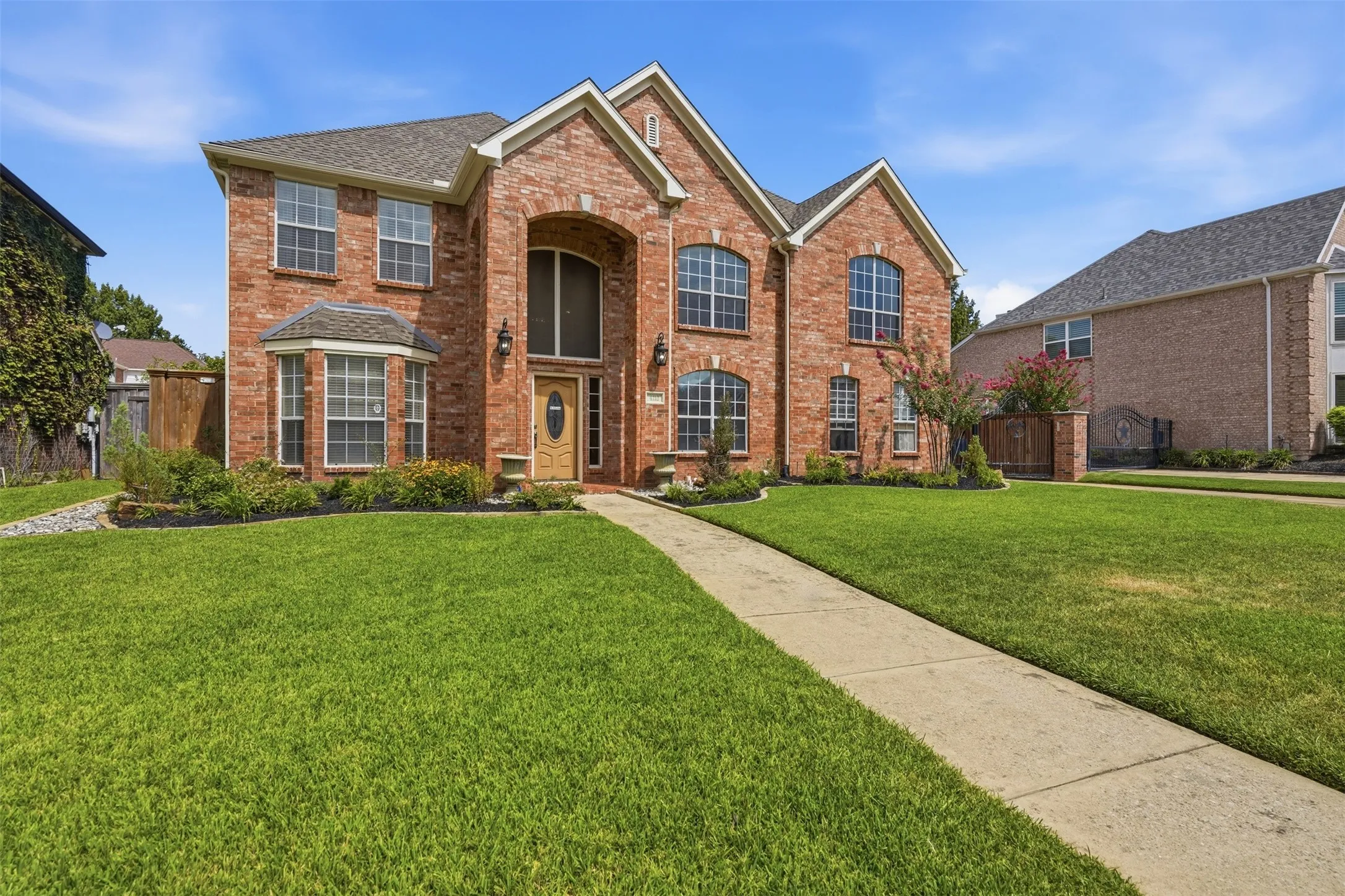 Two-story brick facade residence with a gabled roofline and multiple arched windows