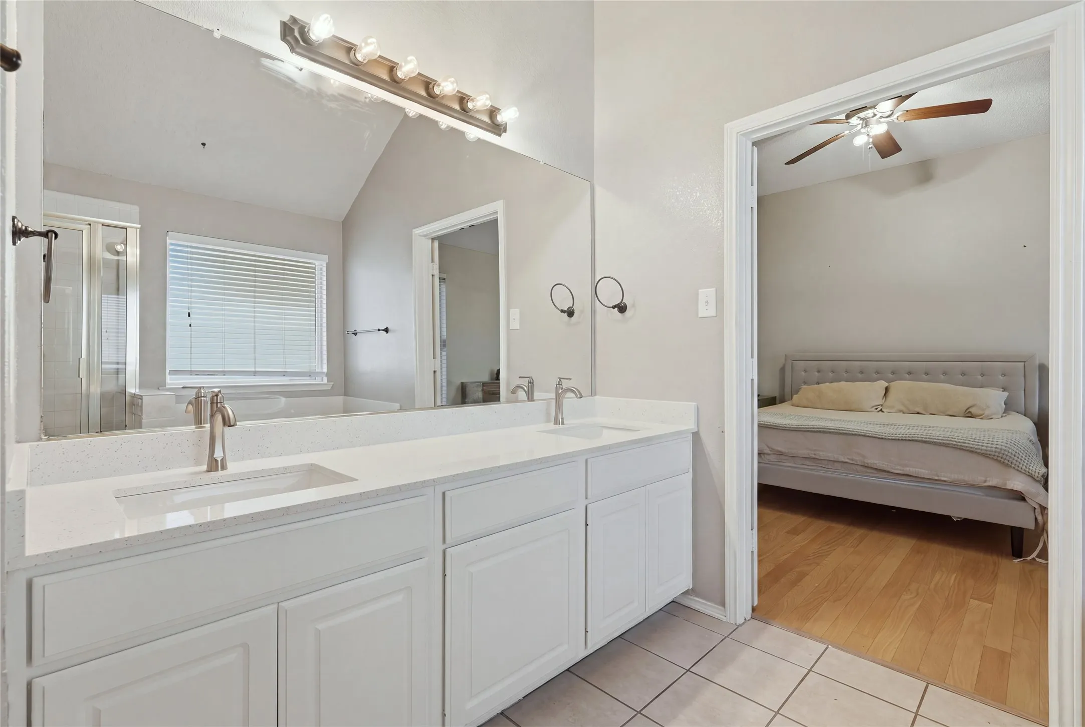 Dual sink vanity with white cabinetry and quartz countertops
