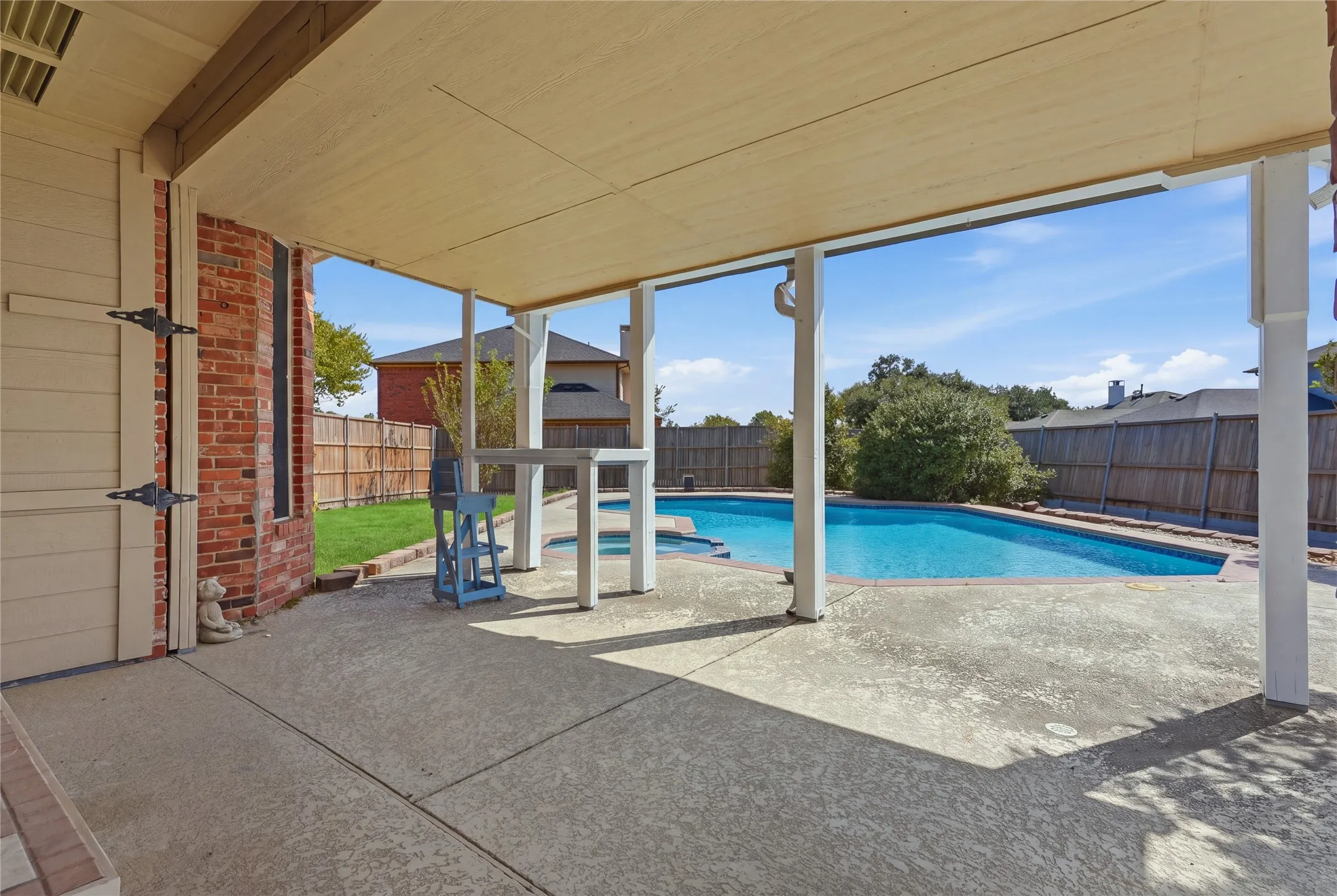 Covered patio with a concrete surface, supported by white columns