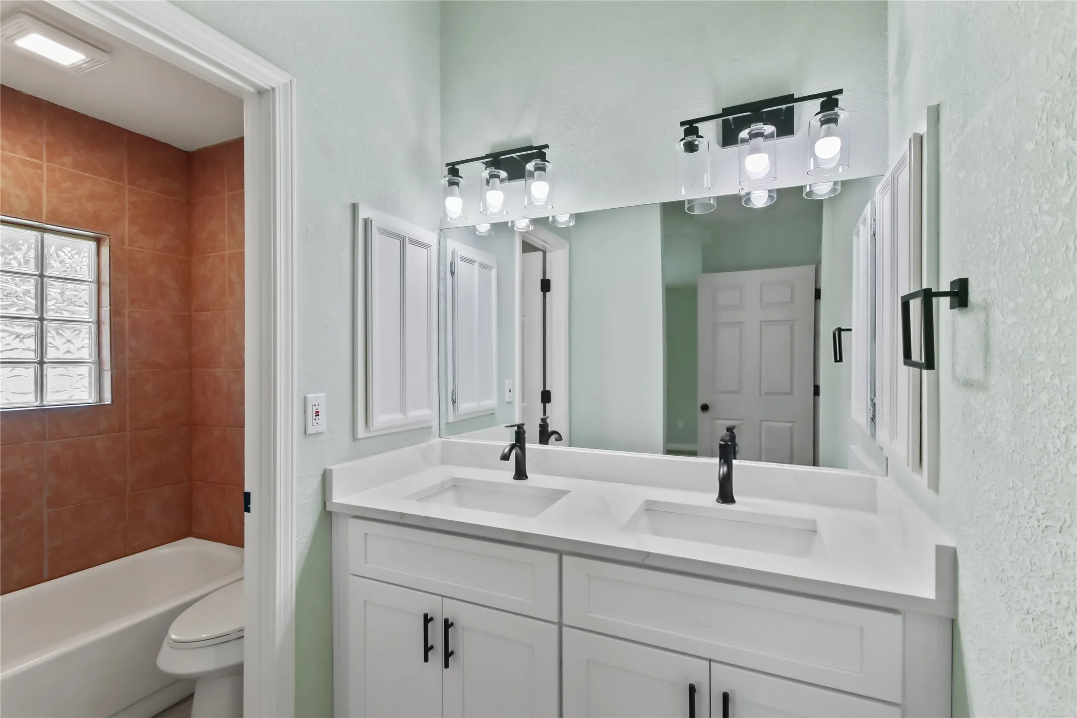 Dual vanity with white cabinetry and integrated sinks