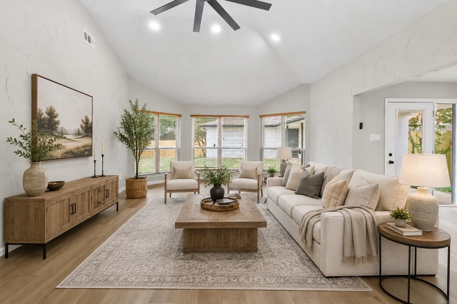 Vaulted ceiling, recessed lighting, wood-finish flooring, bay window, and a rear exterior door