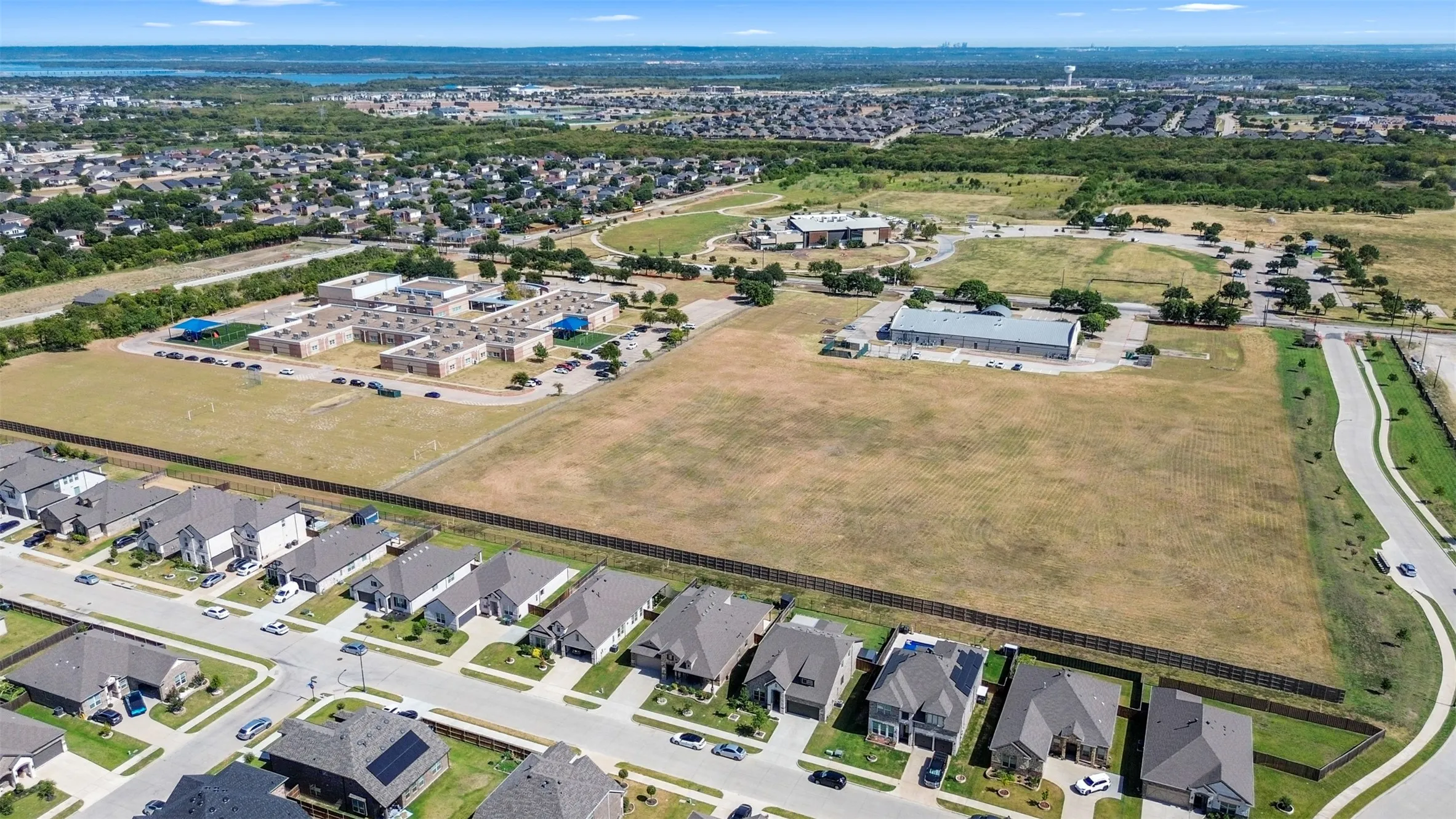 Residential development with varied architectural styles, paved streets, and a greenbelt