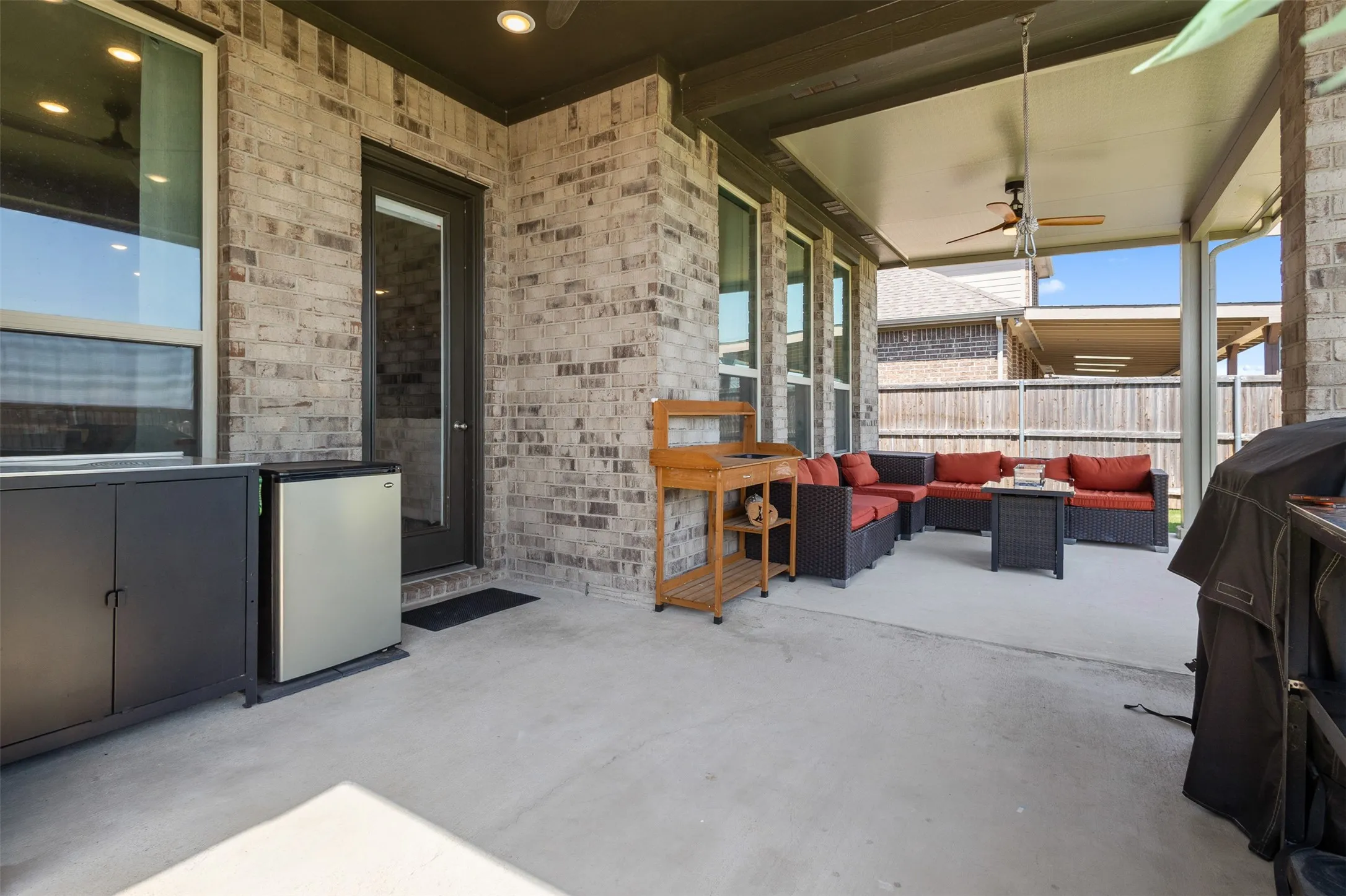 Covered patio featuring a ceiling fan, recessed lighting, and a brick exterior