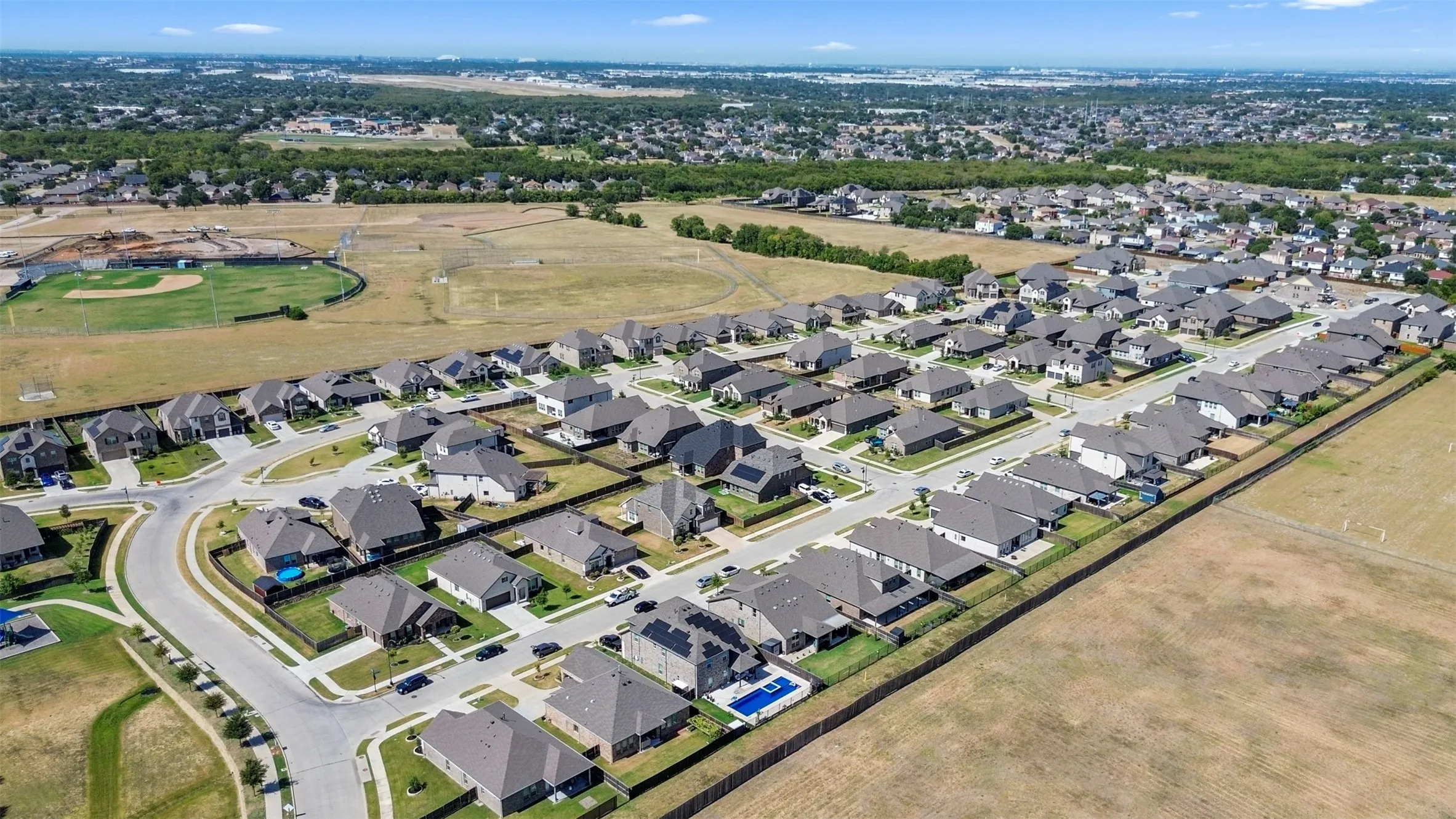 Residential development featuring multiple single-family homes, paved streets, and a suburban setting