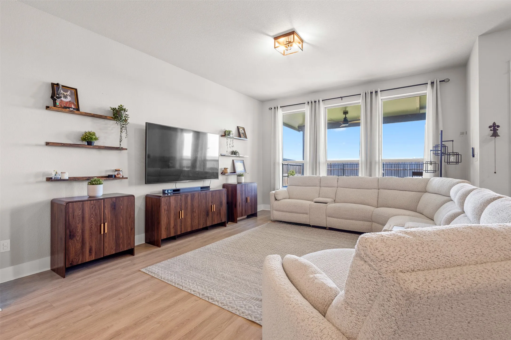 Wood-finish flooring throughout, featuring a series of three tall windows