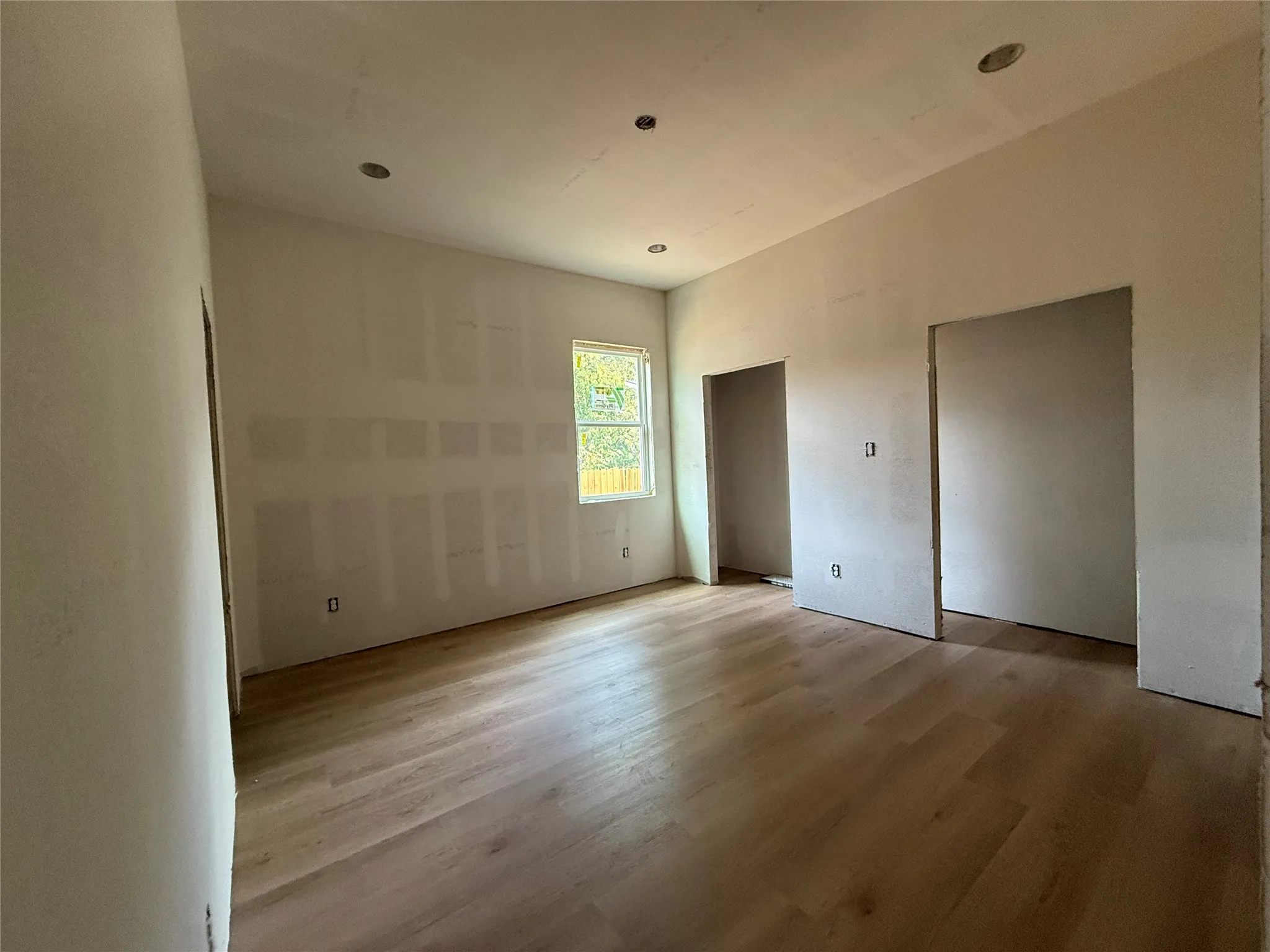 Wood-finish flooring throughout, recessed ceiling lighting, and multiple open doorways