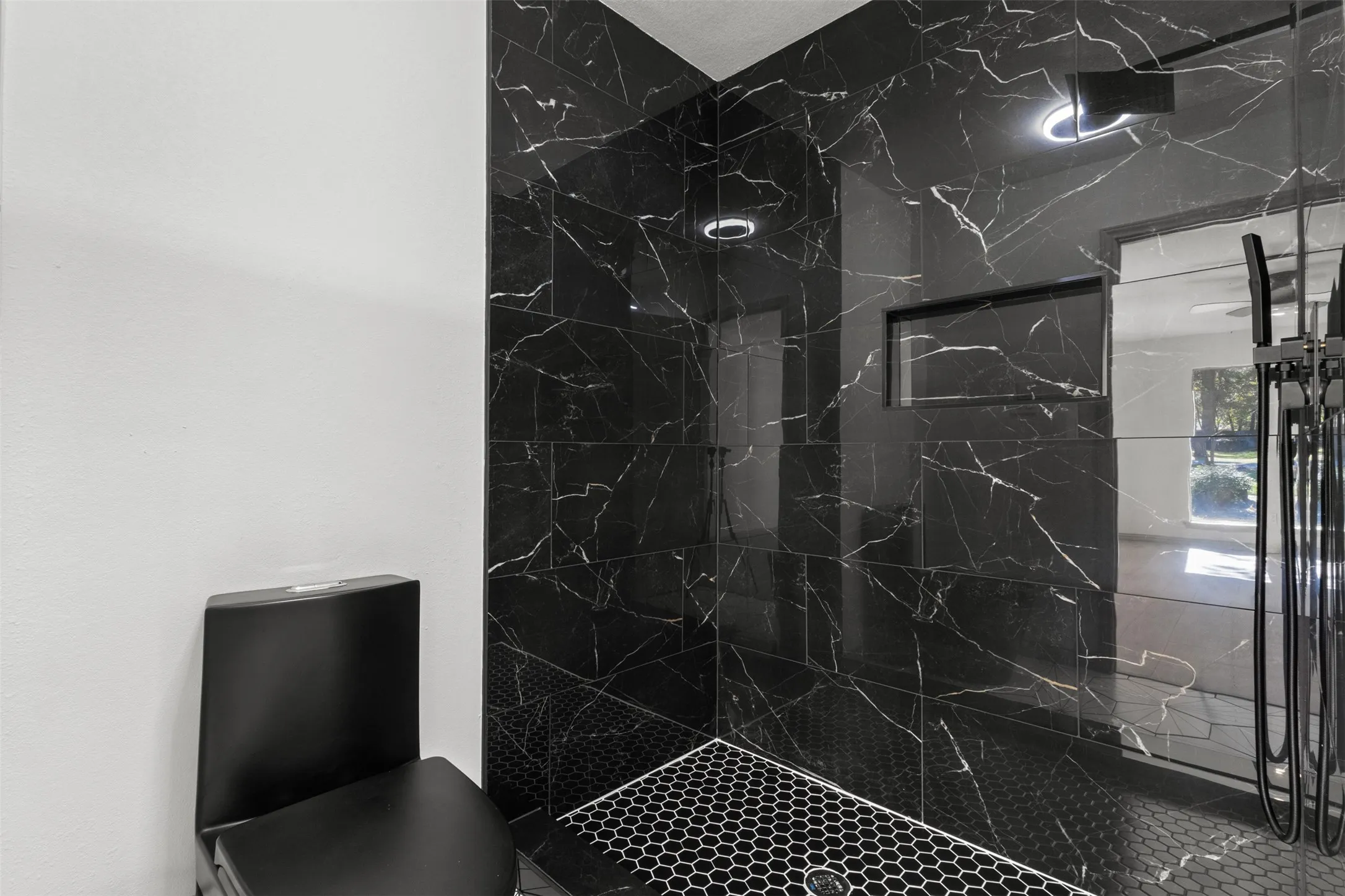 Bathroom with a marble finish shower