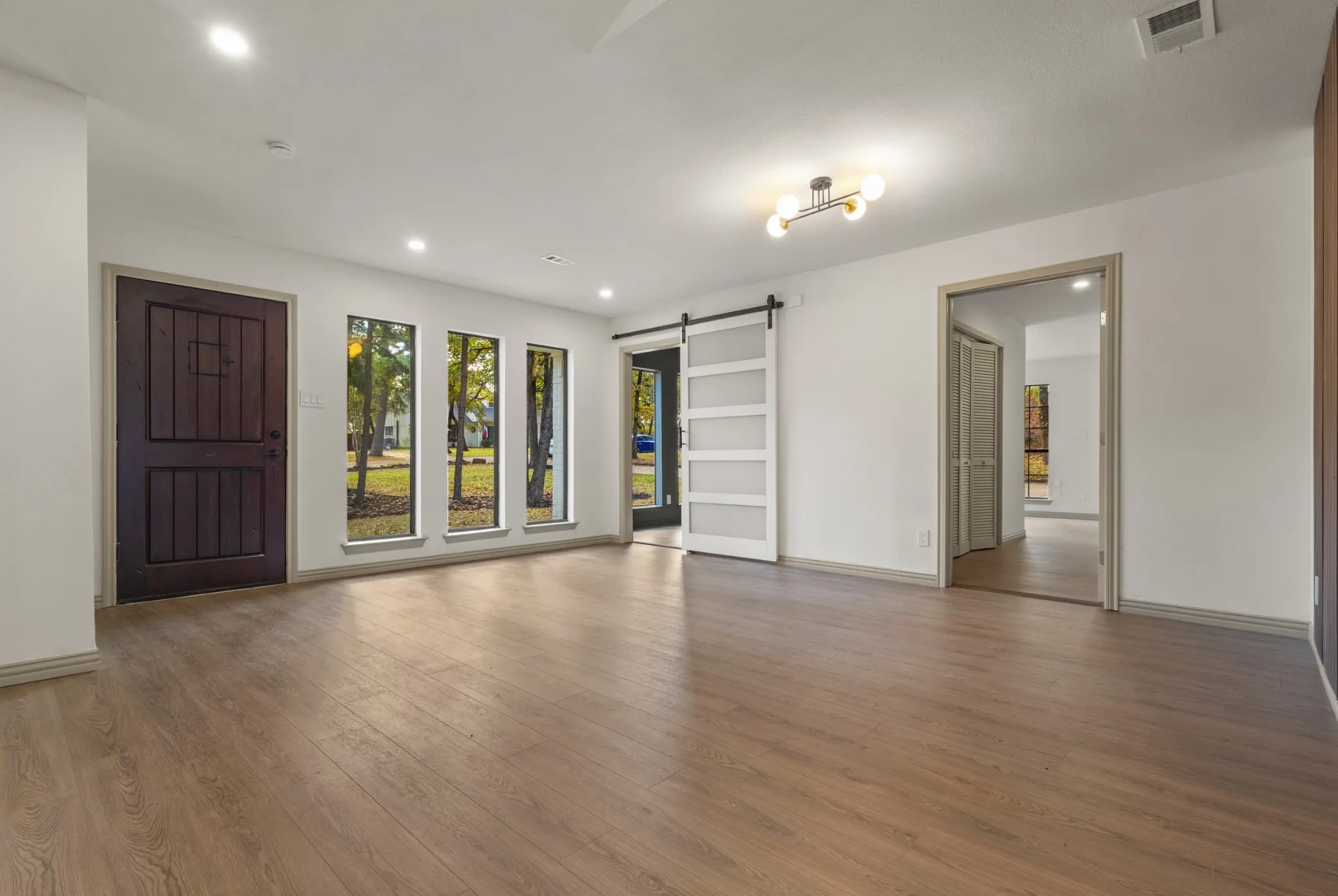 Spare room featuring a barn door, wood finished floors, and recessed lighting