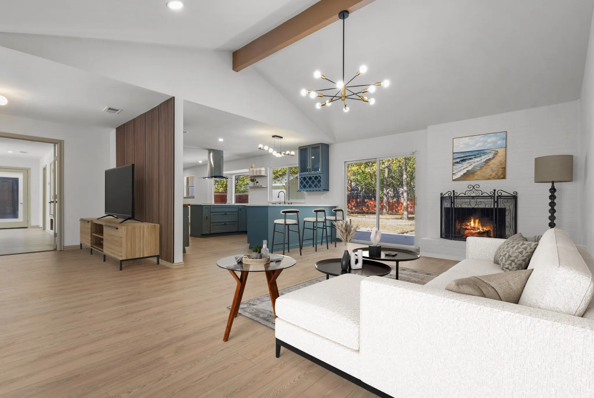 Living area with a chandelier, a brick fireplace, light wood-type flooring, beamed ceiling, and recessed lighting