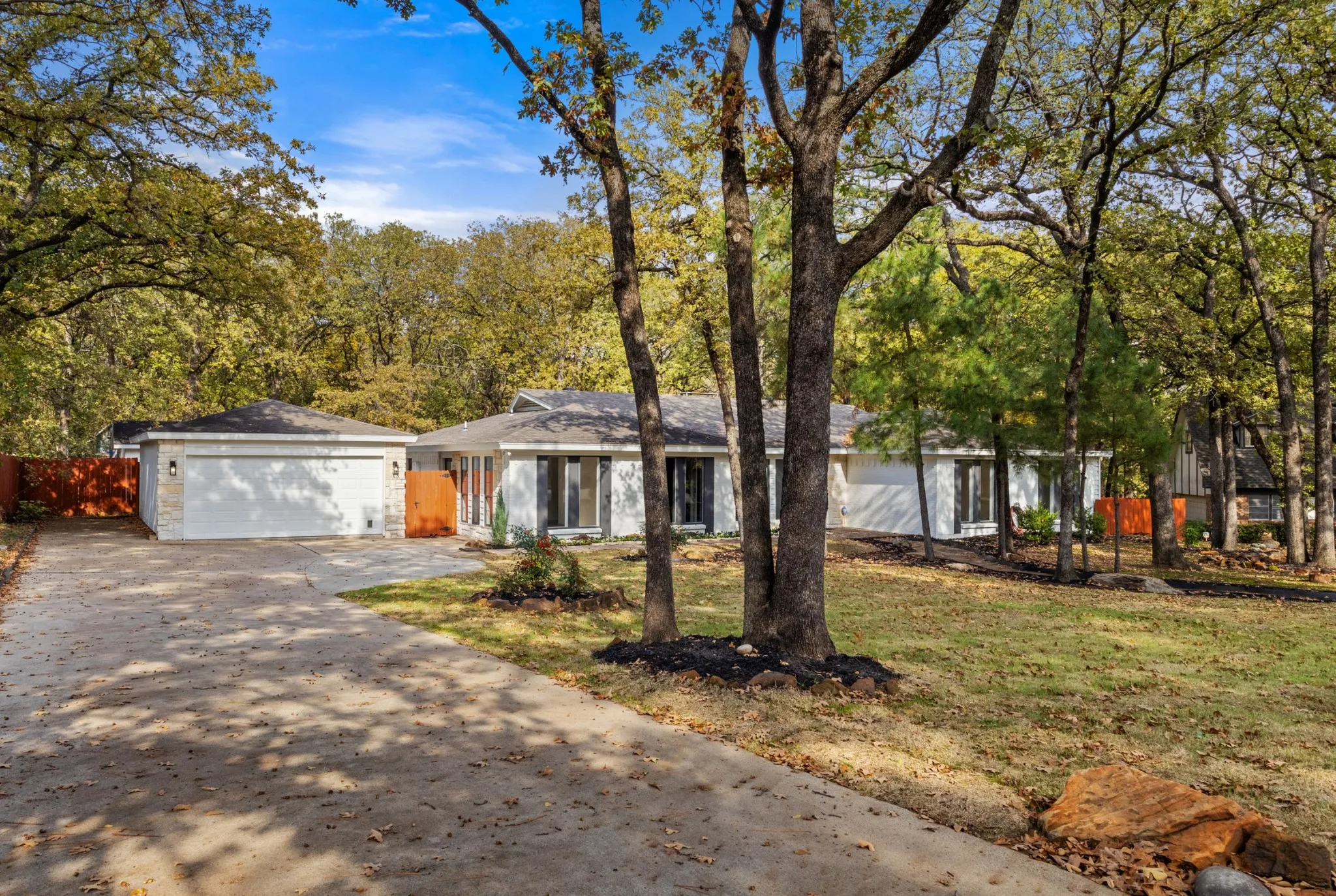 Ranch-style home with a garage, concrete driveway, and a shingled roof