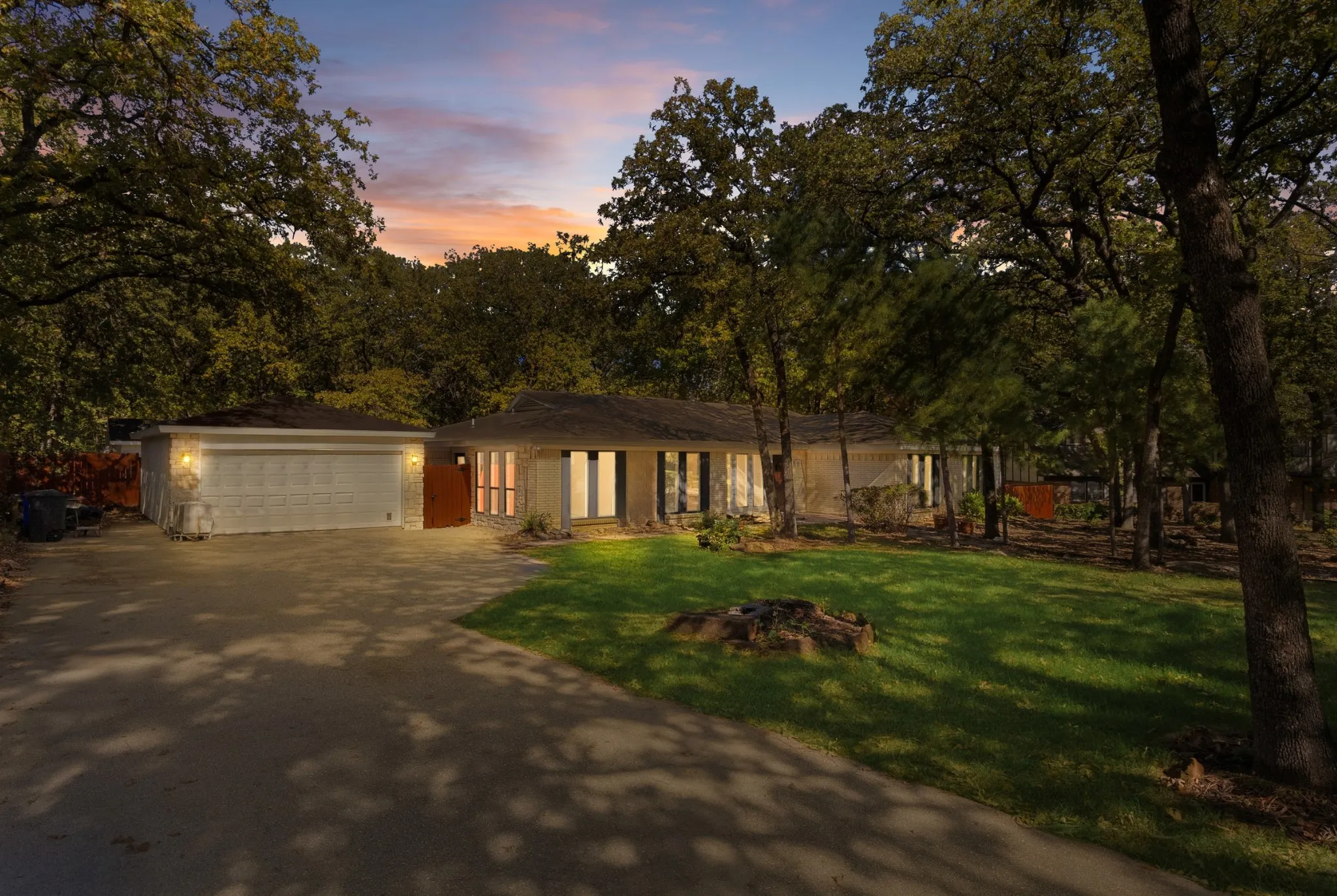 View of front of property featuring driveway and a yard