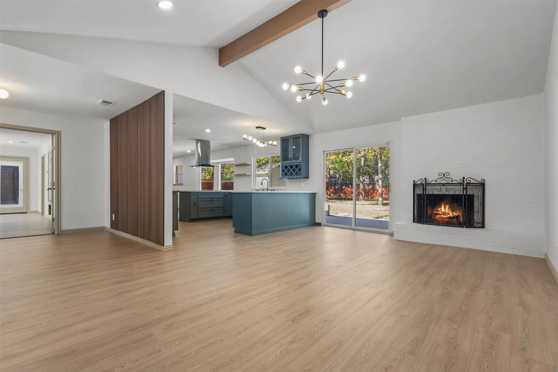 Unfurnished living room featuring a chandelier, a brick fireplace, light wood-style floors, and recessed lighting