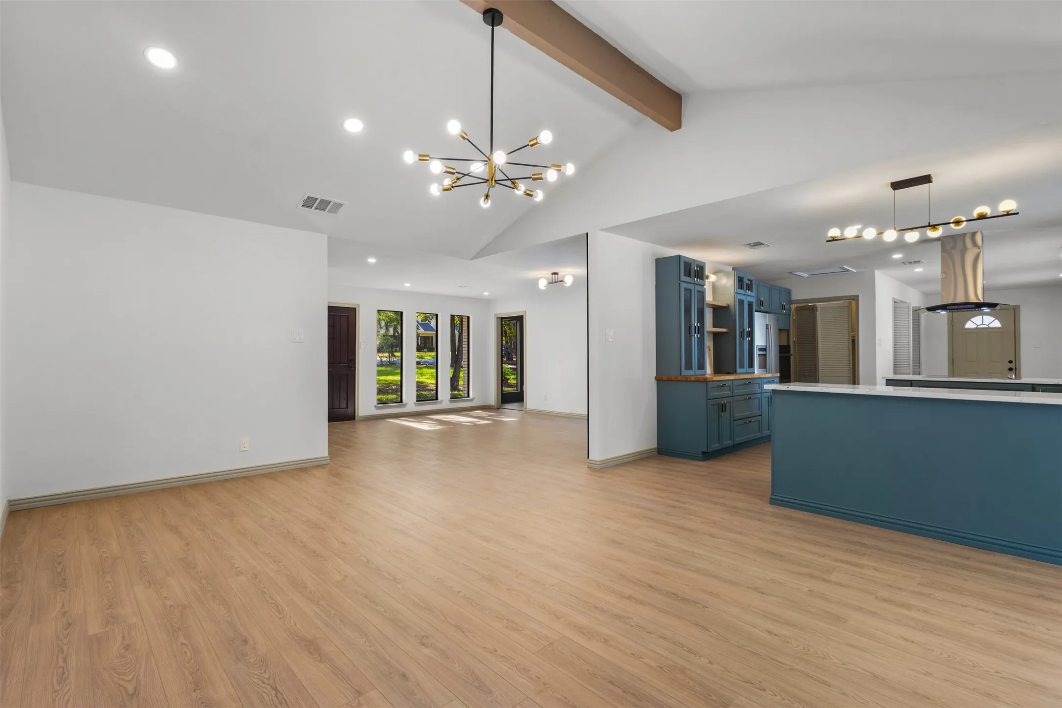 Unfurnished living room with beamed ceiling, light wood-style floors, a chandelier, recessed lighting, and high vaulted ceiling