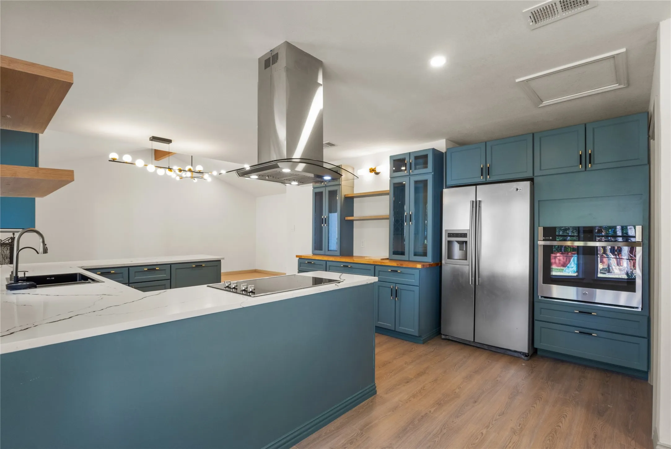 Kitchen featuring open shelves, blue cabinetry, appliances with stainless steel finishes, island range hood, and recessed lighting