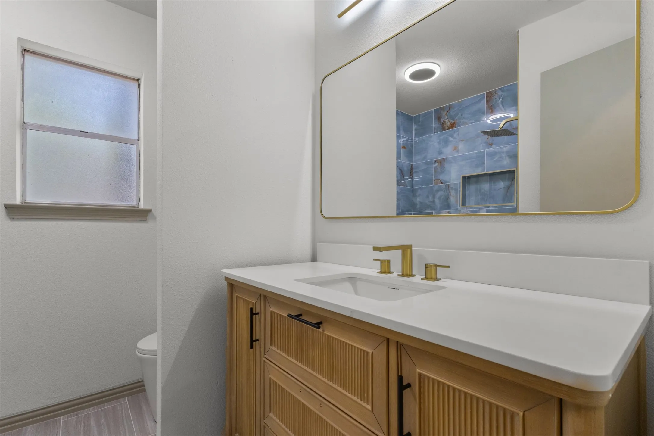 Bathroom featuring vanity and tiled shower