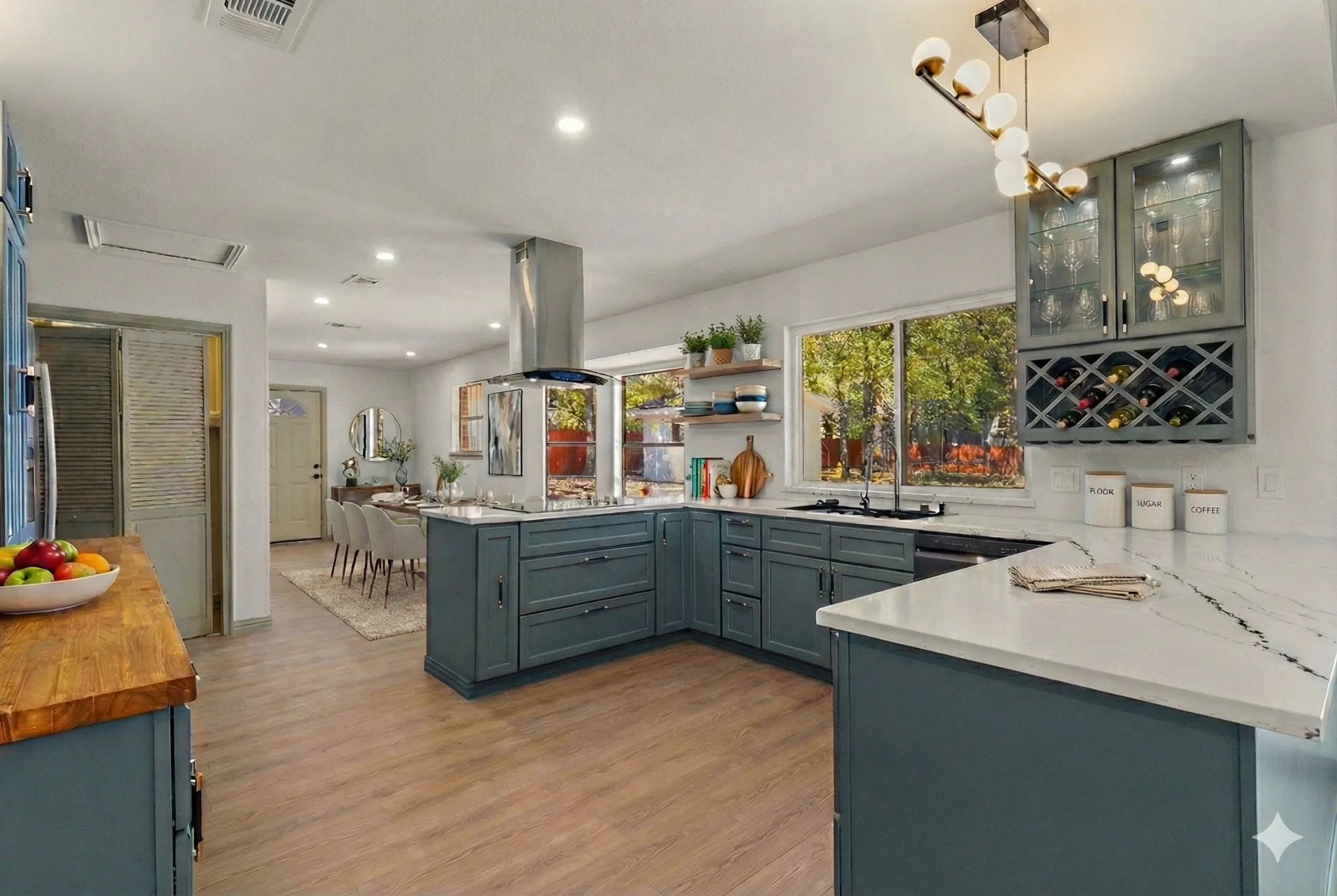 Kitchen with a peninsula, hanging light fixtures, light wood-type flooring, recessed lighting, and island exhaust hood