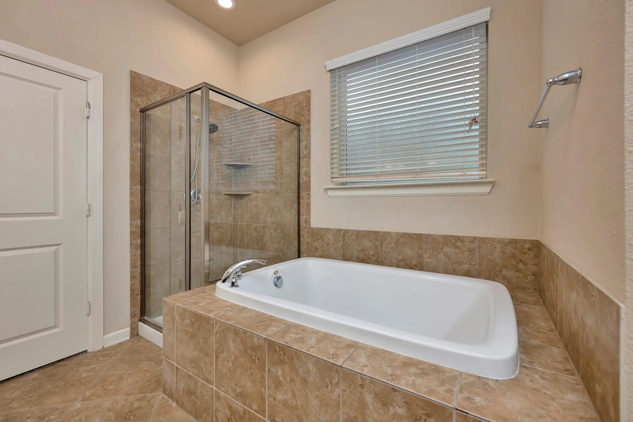 Walk-in shower with clear glass enclosure and built-in shelving