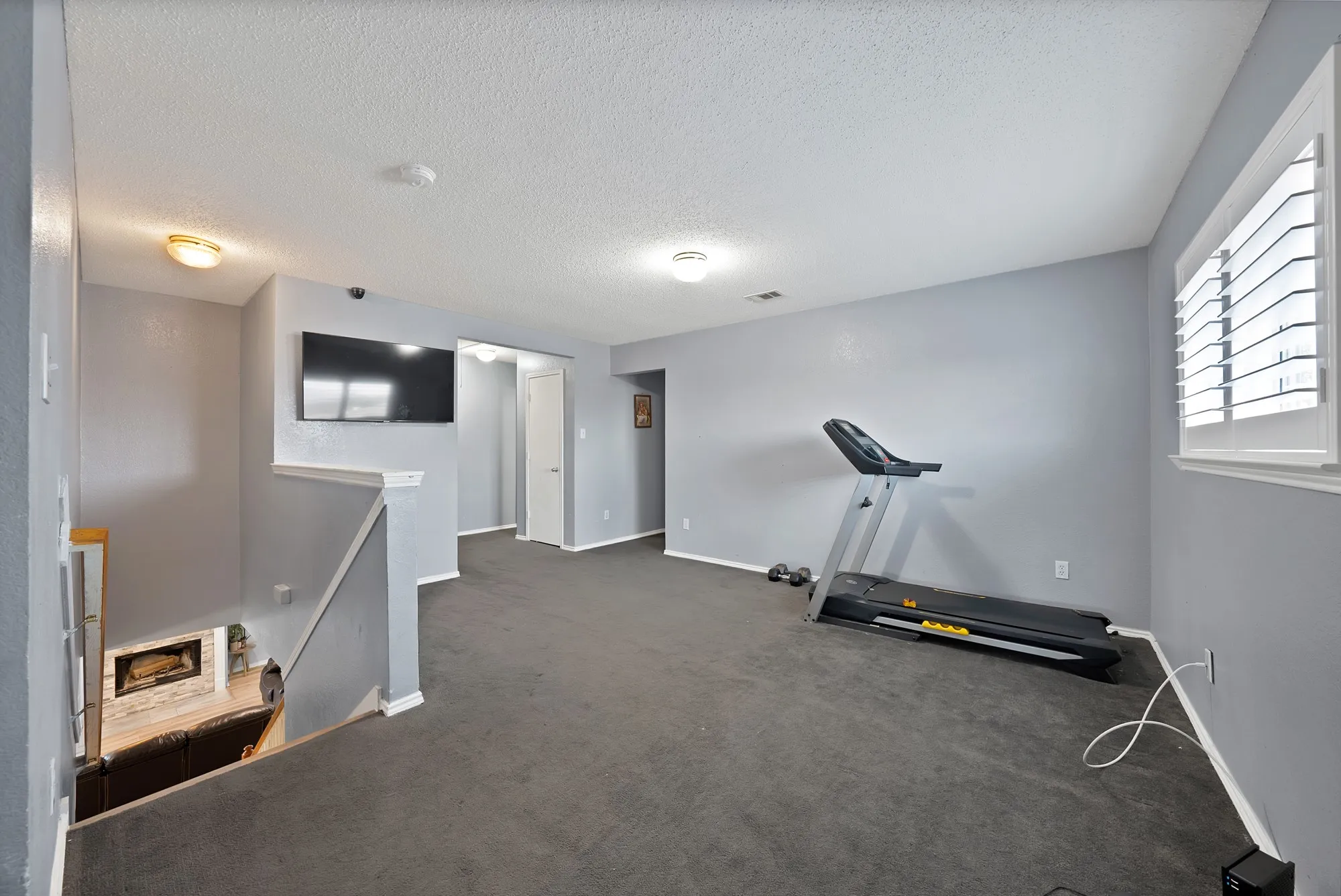 Upper-level space featuring wall-to-wall carpeting, recessed lighting, and a window with plantation shutters