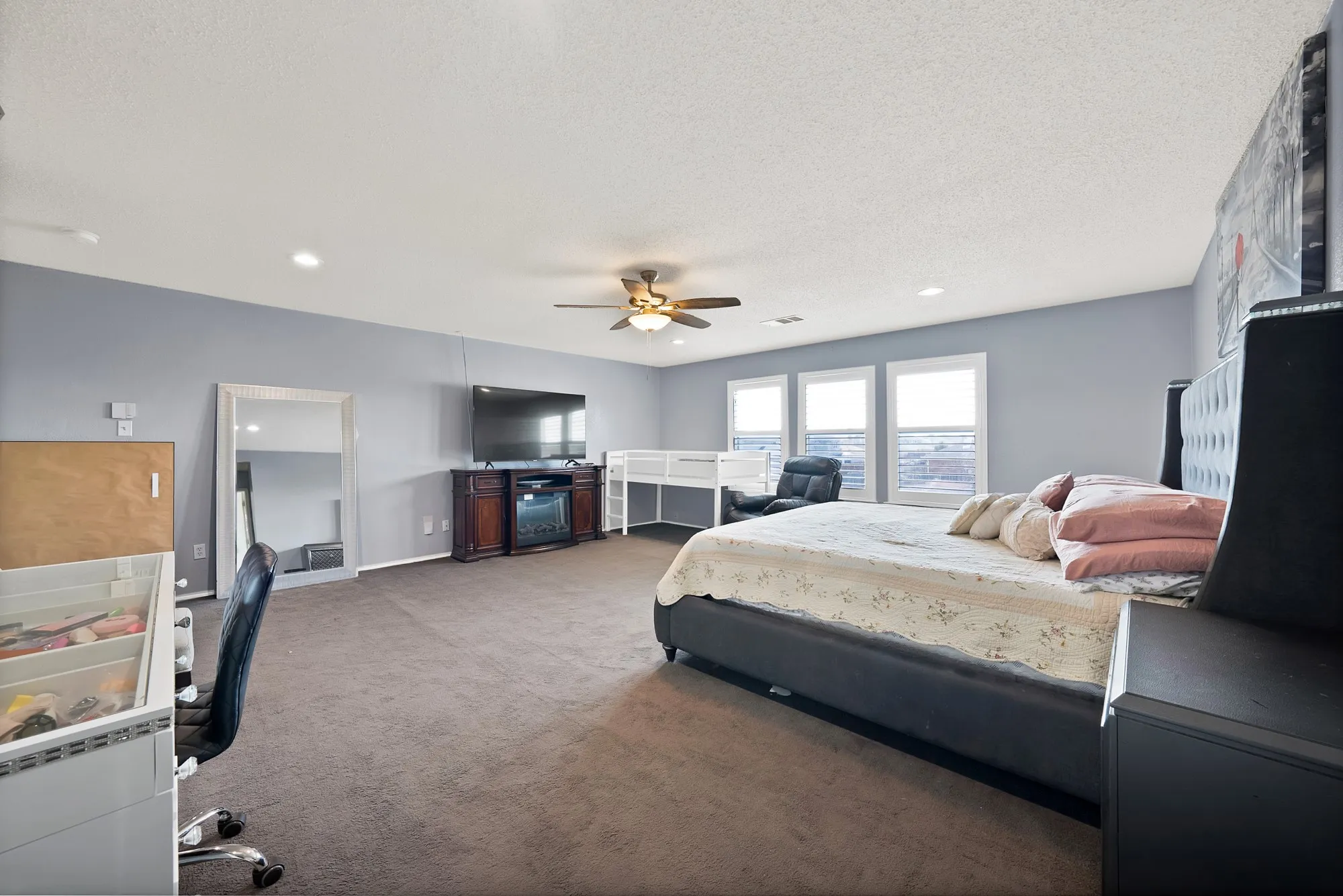 Recessed lighting, ceiling fan, multiple windows, and carpeted flooring
