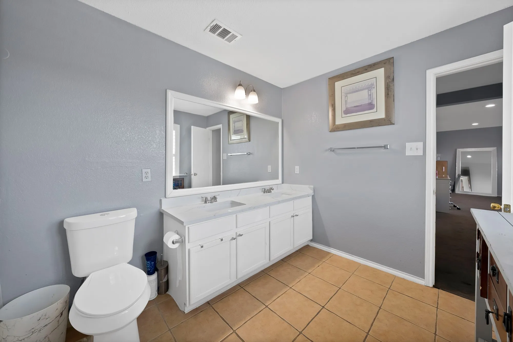 Dual vanity with integrated sinks, framed mirror, and white cabinetry