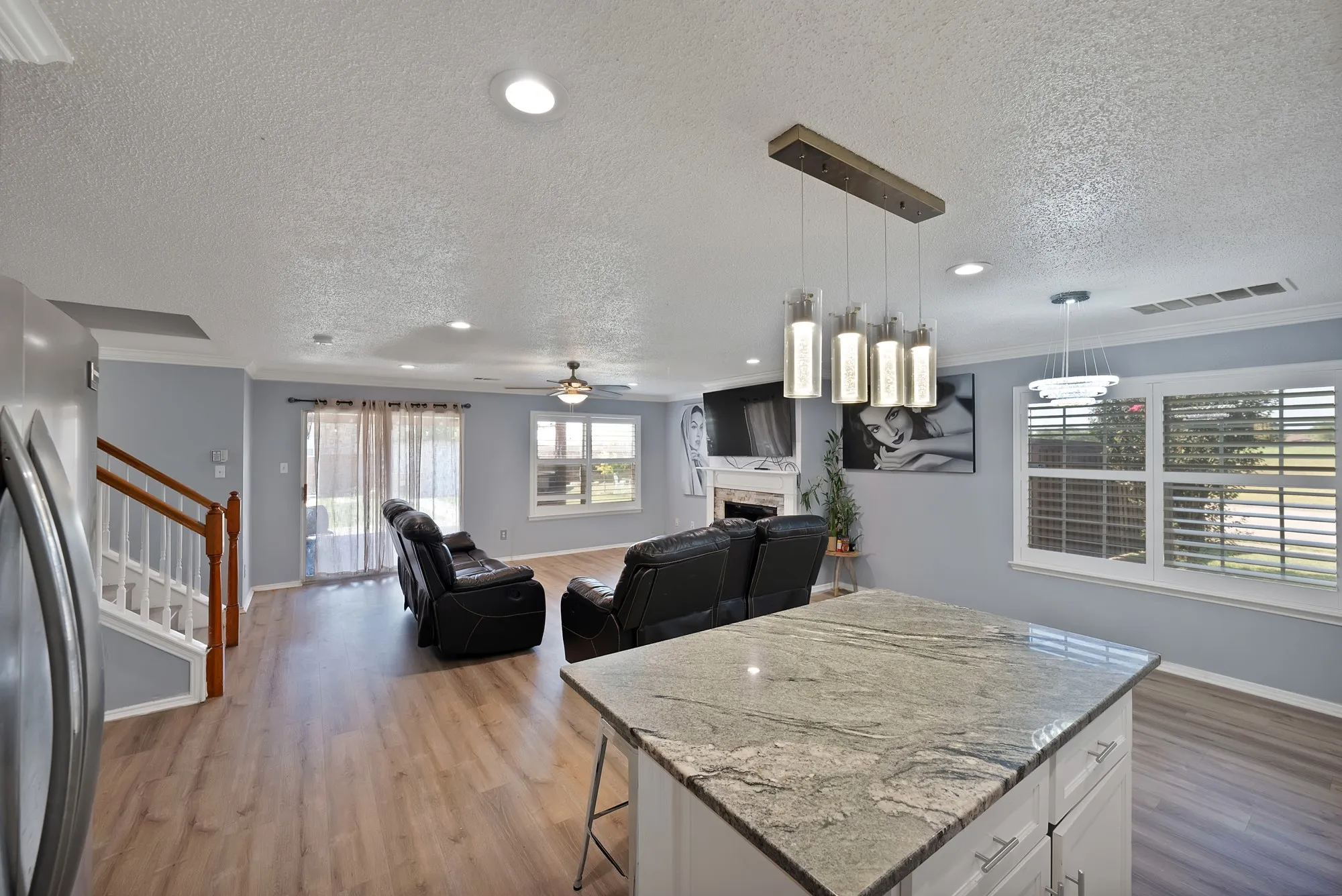 Kitchen island with granite countertop, wood-finish flooring, recessed lighting, and a modern linear pendant fixture