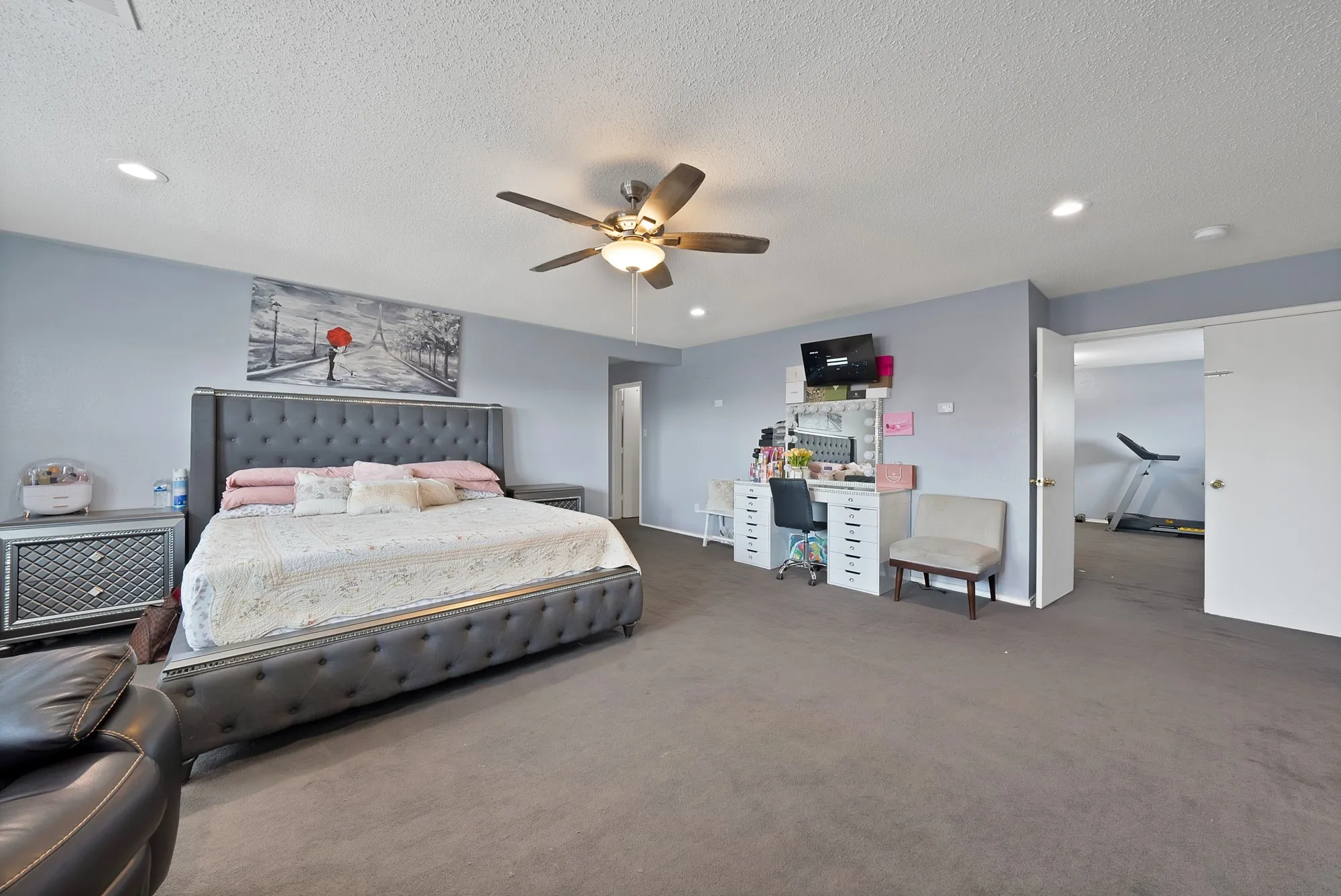 Recessed lighting, ceiling fan with integrated light, and gray carpeting