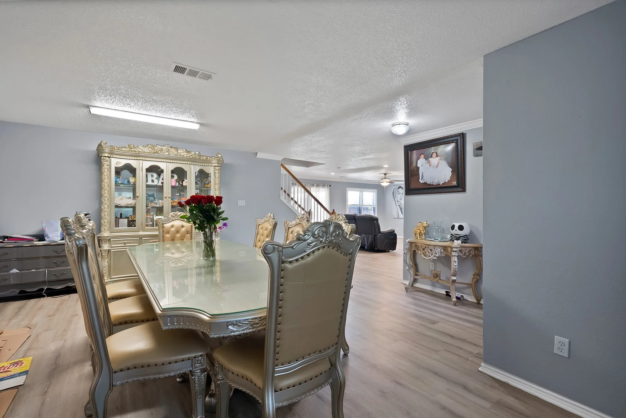Wood-finish flooring throughout, light gray wall paint, white crown molding, and recessed lighting
