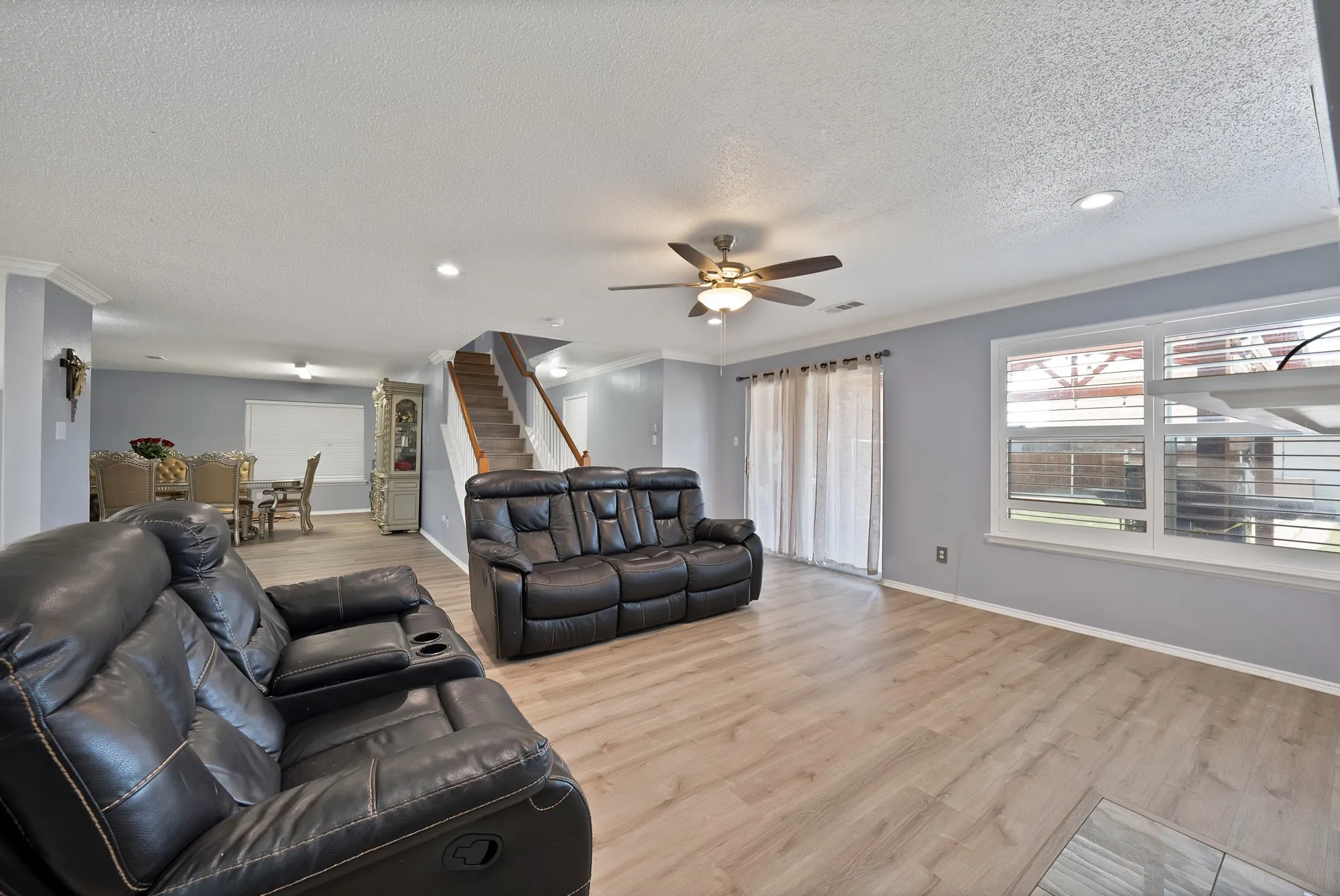 Spacious living area featuring wood-finish flooring, recessed lighting, and a ceiling fan
