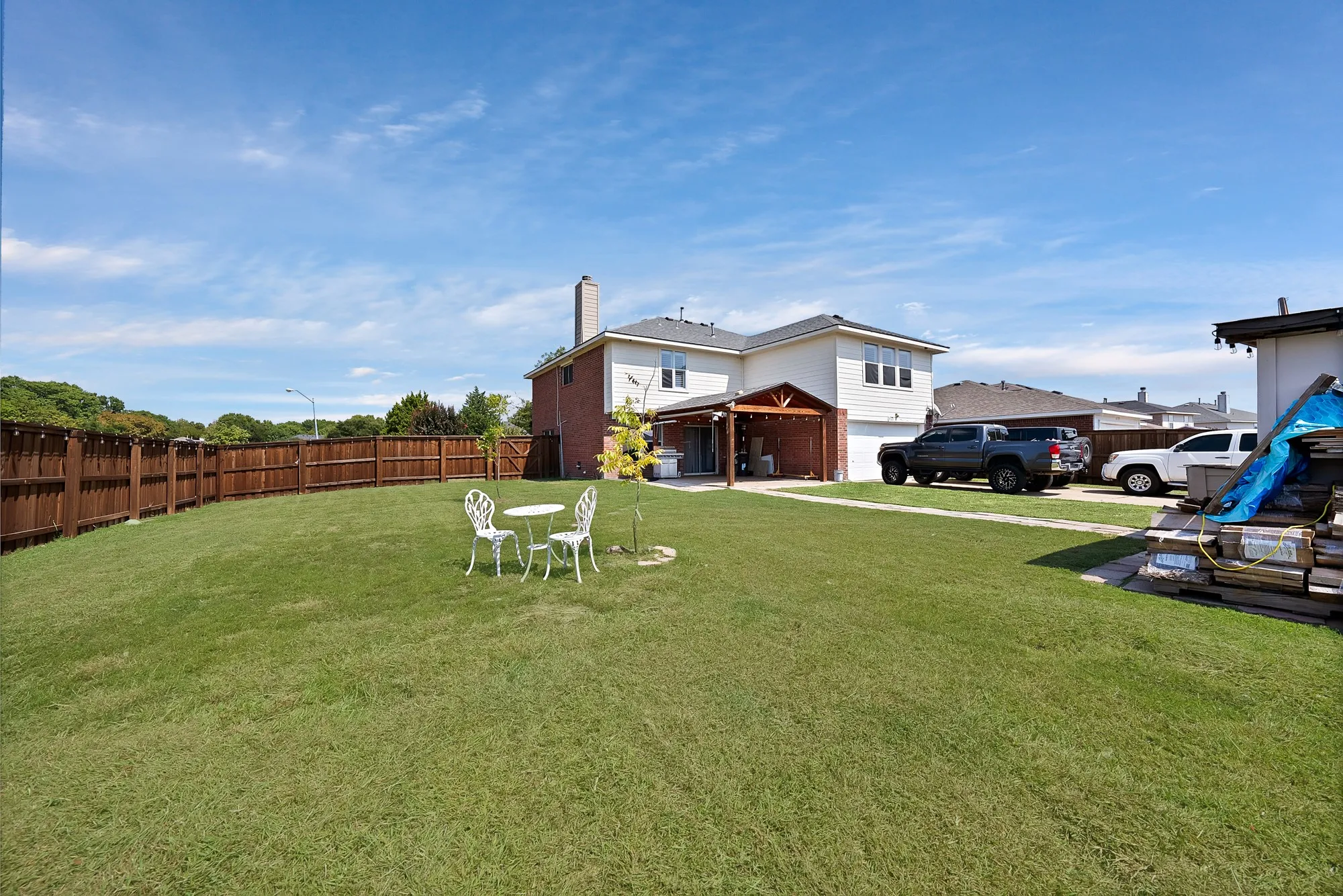 Expansive green lawn with a full privacy fence